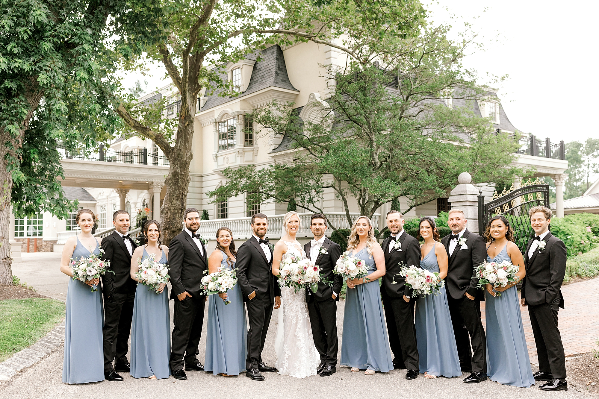 bride and groom stand with wedding party in blue and black for classic summer wedding at the Ashford Estate