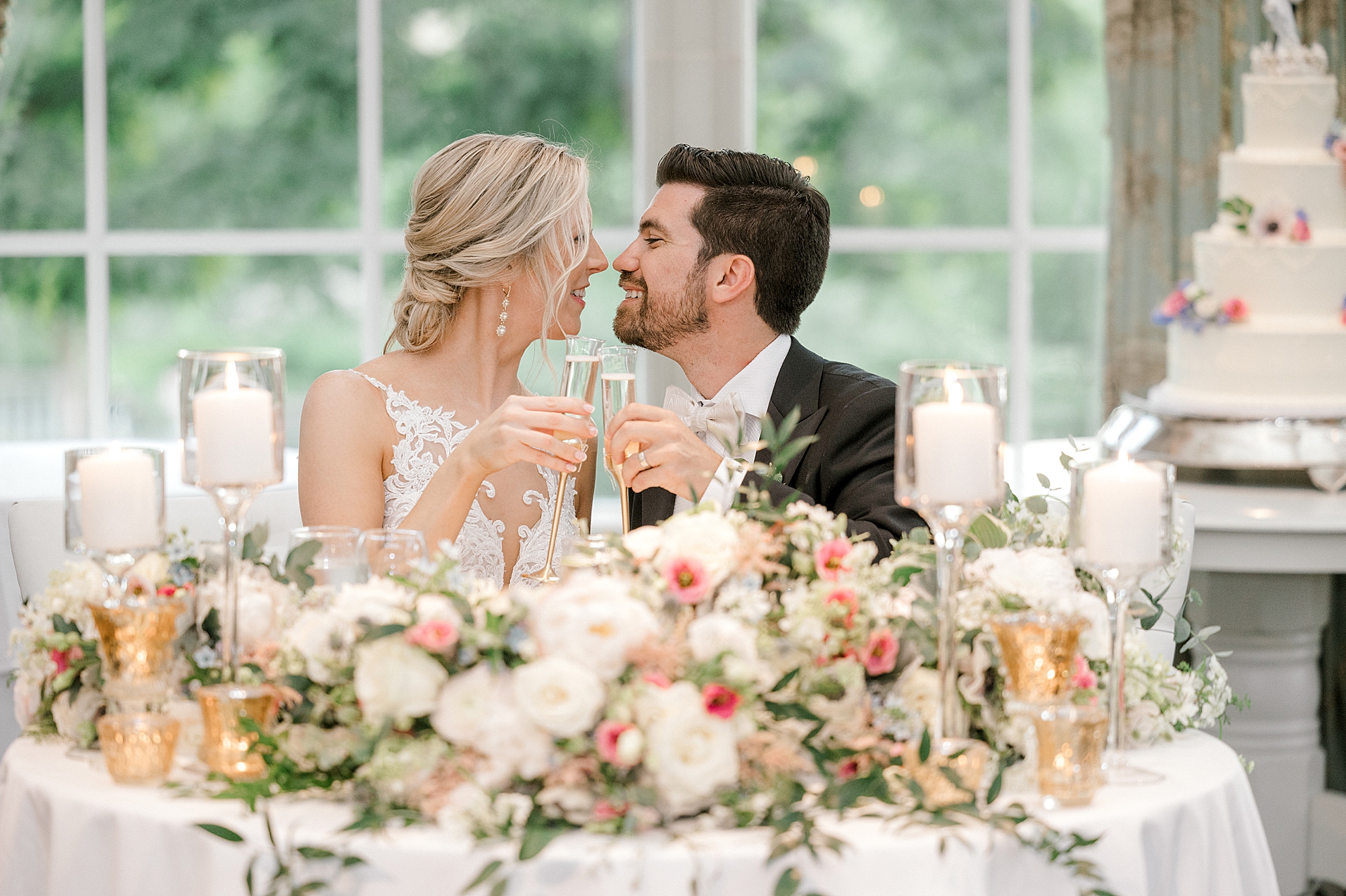 newlyweds smile touching noses with glasses of wine