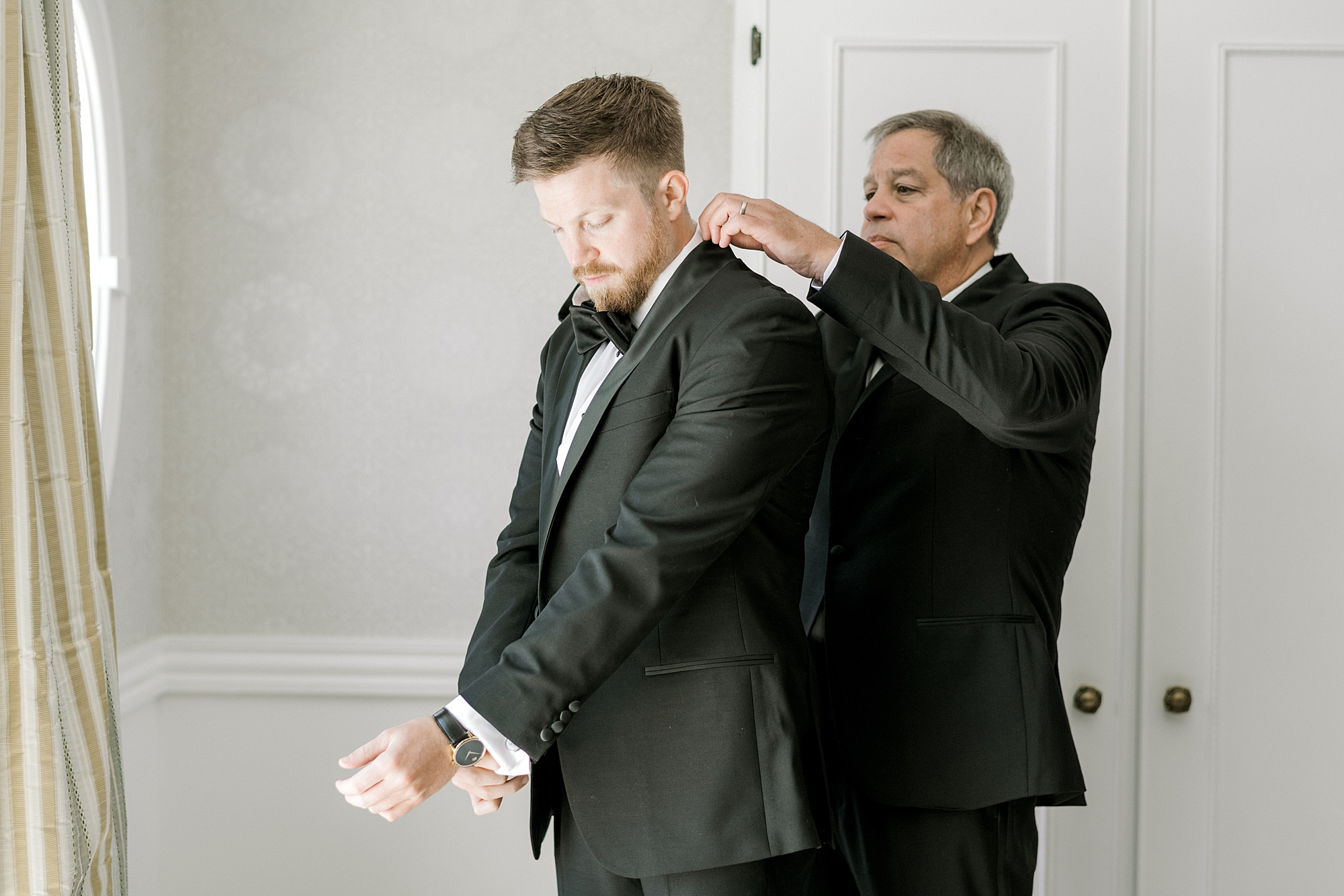 father helps groom with bowtie and jacket collar before Bonnet Island Estate wedding