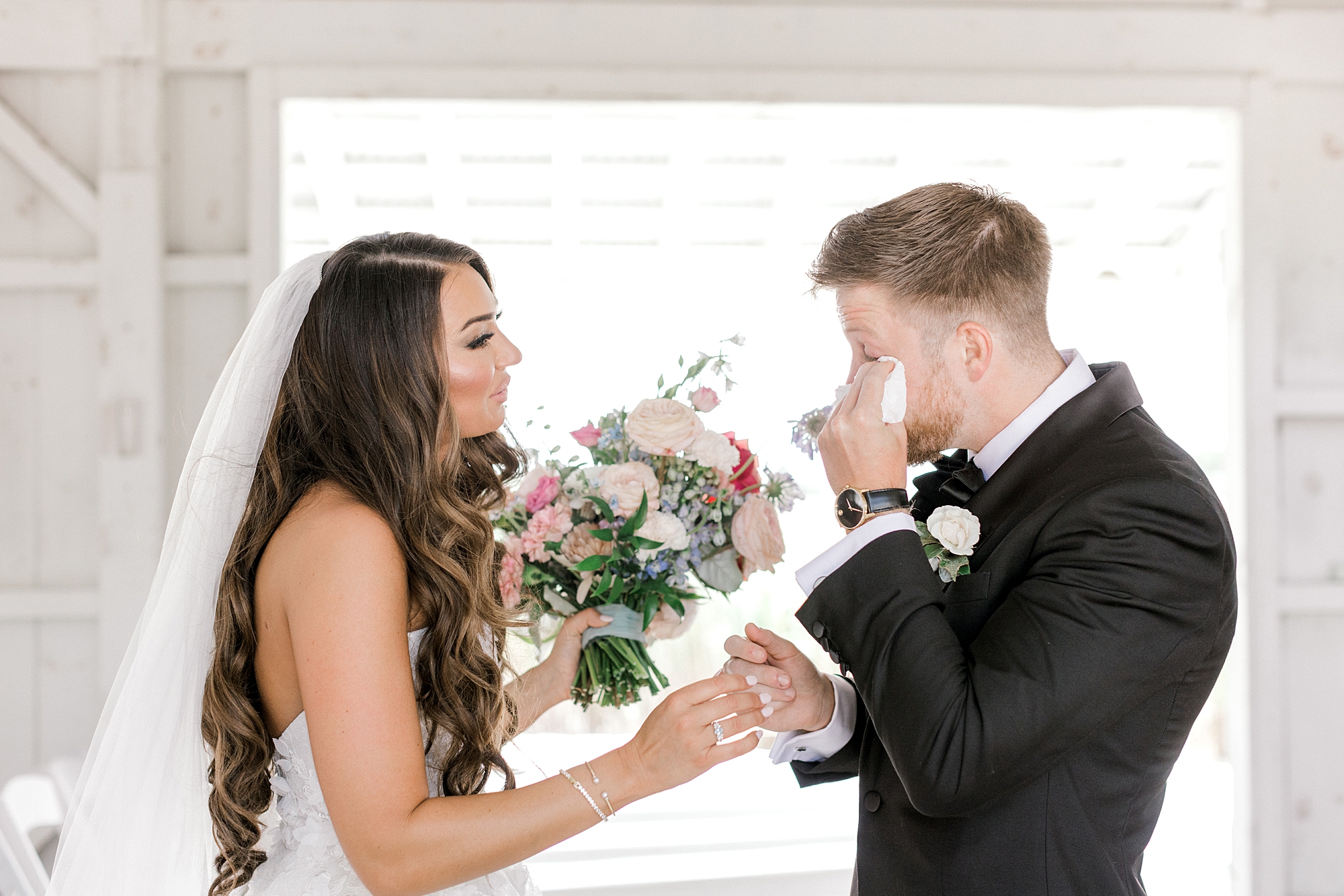 groom wipes away tears during first look with bride at Bonnet Island Estate