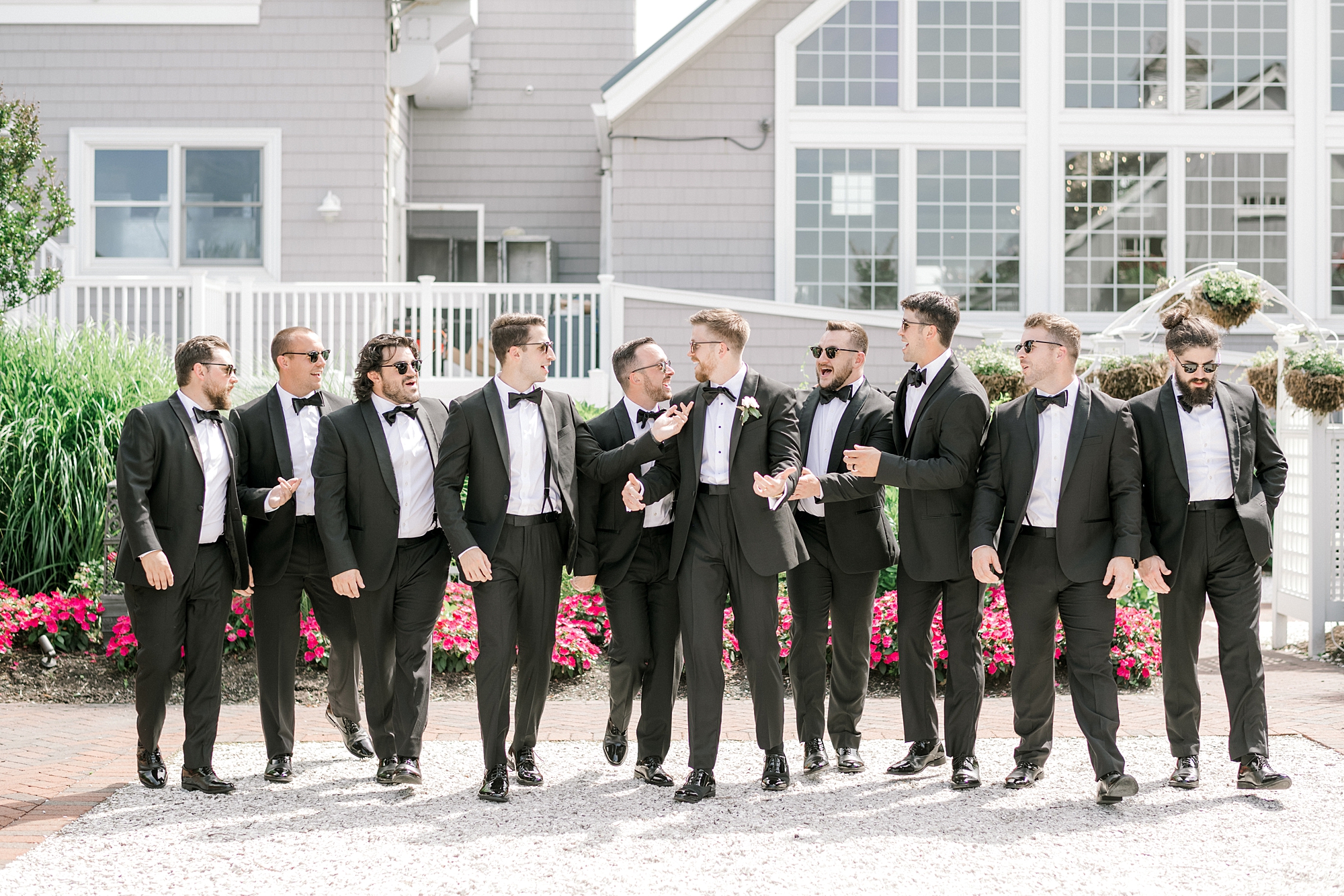 groom talks with groomsmen while walking in front of Bonnet Island Estate