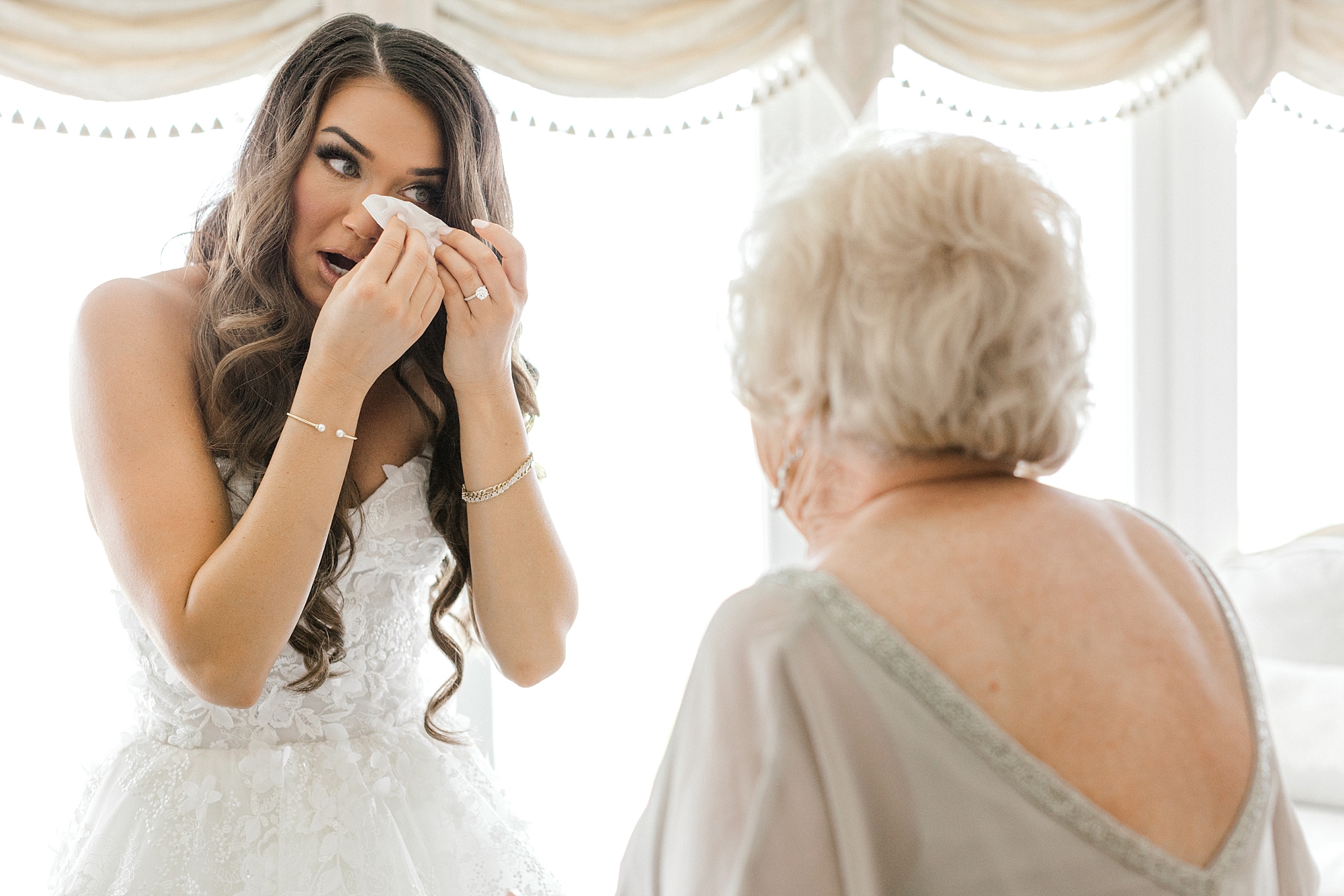 bride wipes away tears during first look with grandmother before LBI wedding