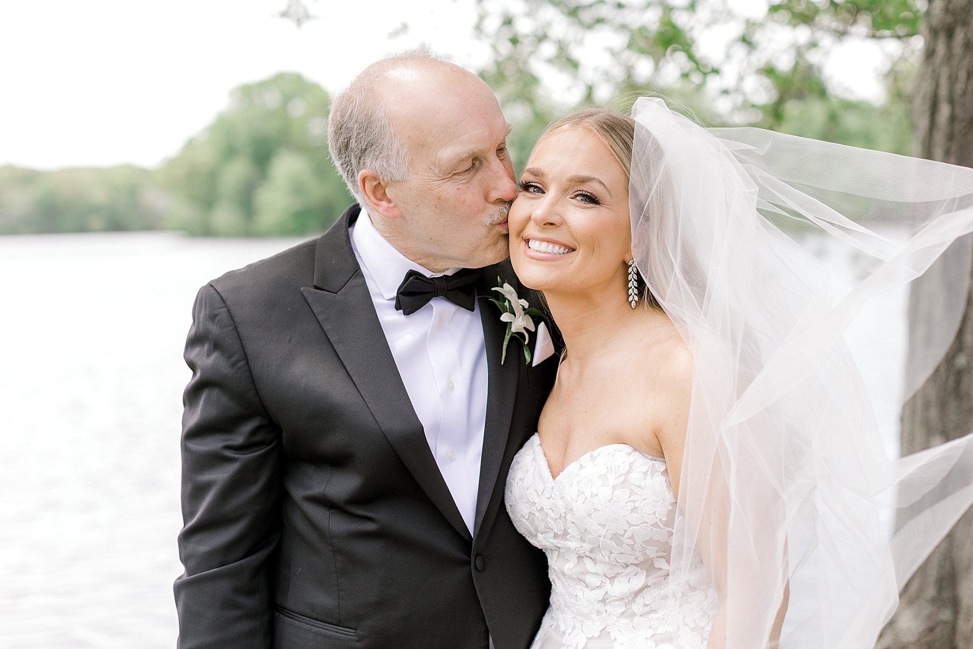 dad kisses bride's cheek by Franklin Lake at Indian Trail Club