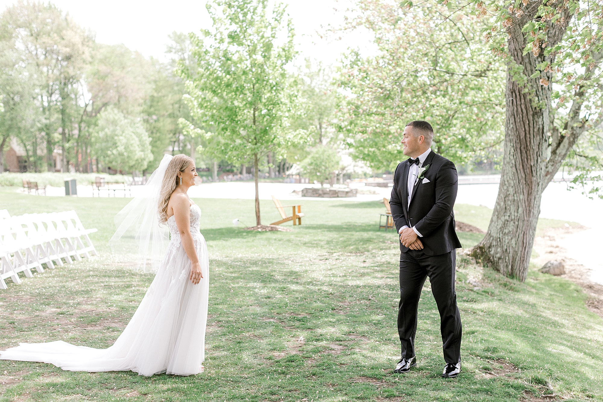groom in black suit turns to look at bride during first look