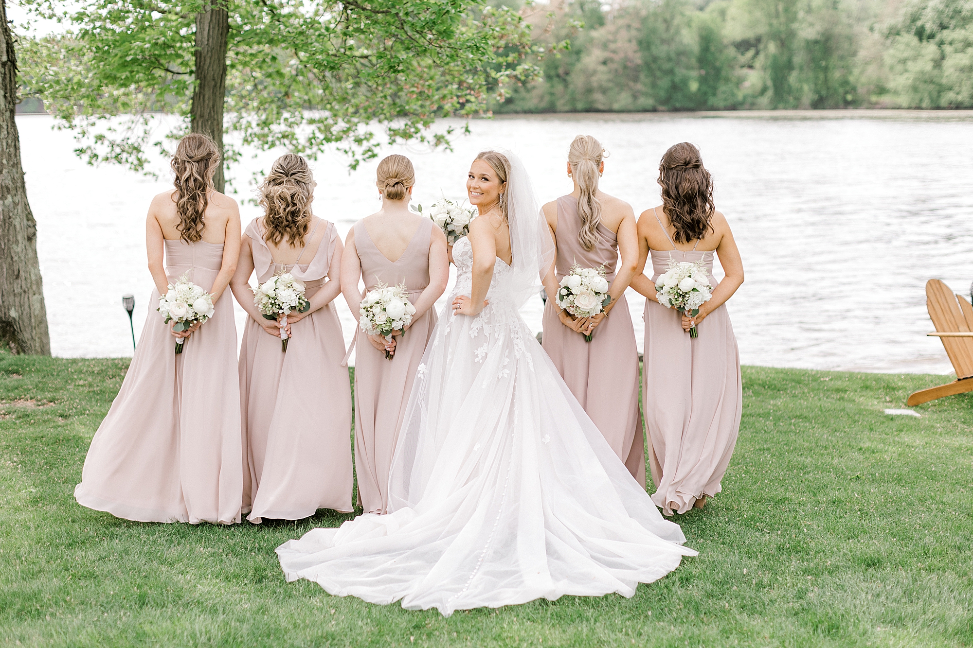 bride stands with bridesmaids and turns to look back