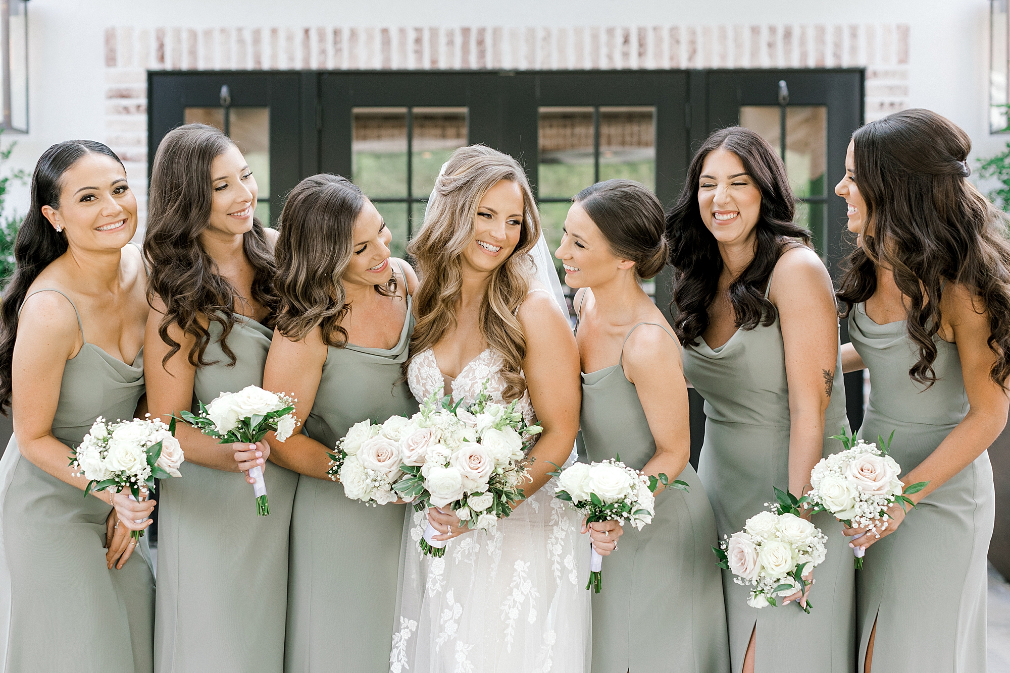 bride smiles at bridesmaids in sage green gowns at the Refinery at Perona Farms