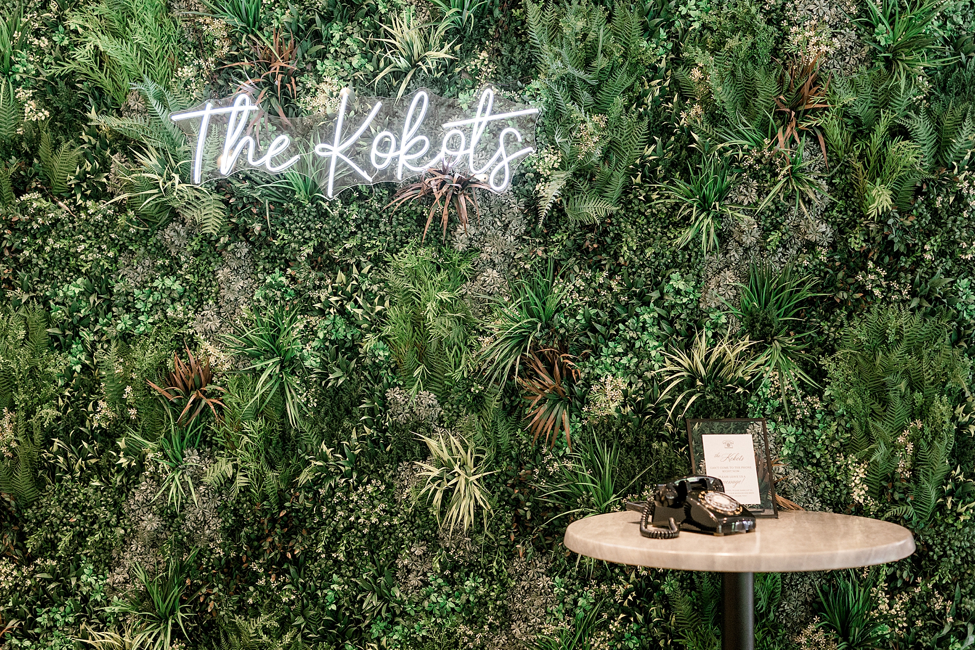 greenery wall with custom neon sign "THE KOBOTS" with audio guestbook