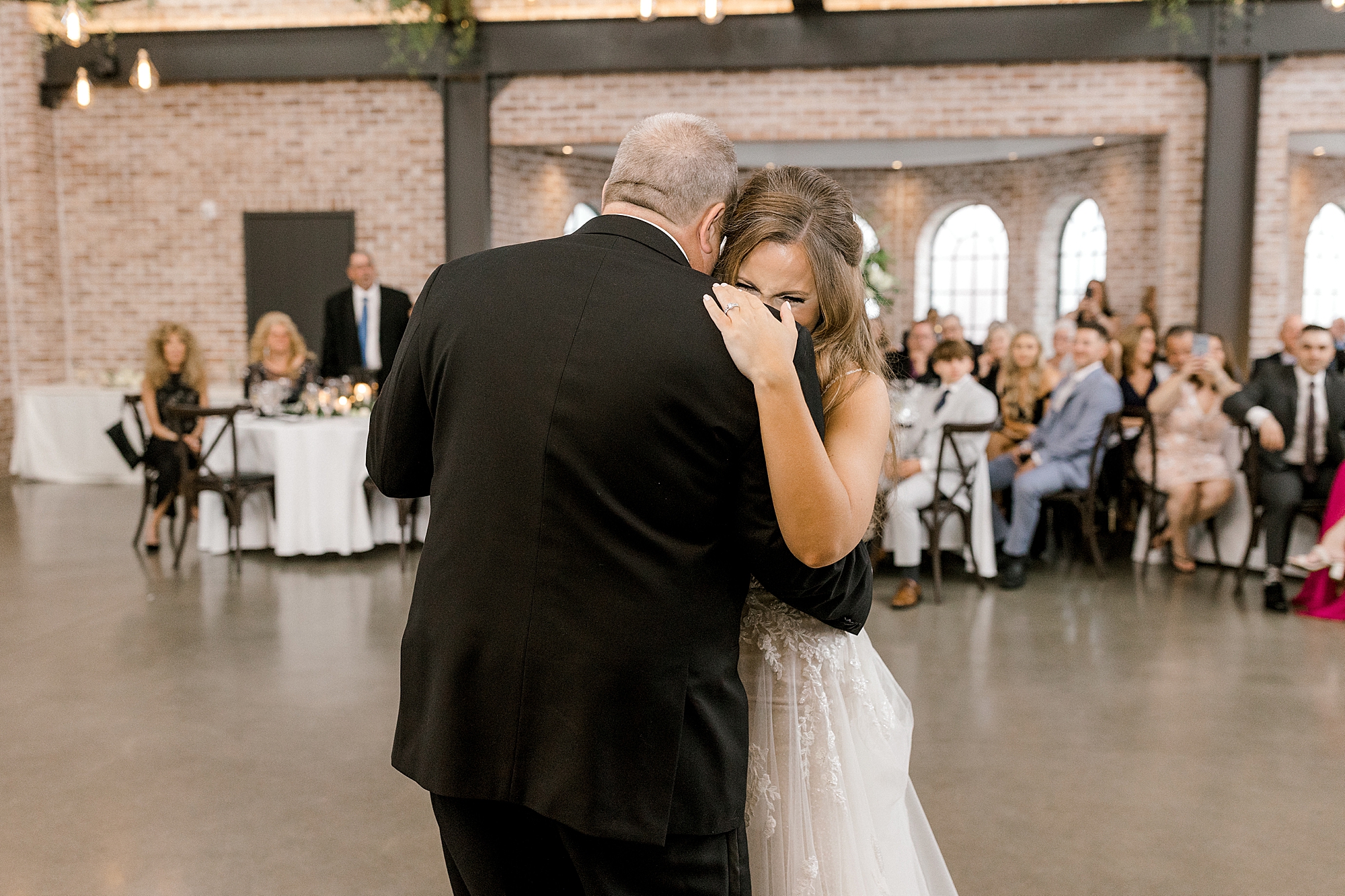 bride cries into father's shoulder at the Refinery at Perona Farms