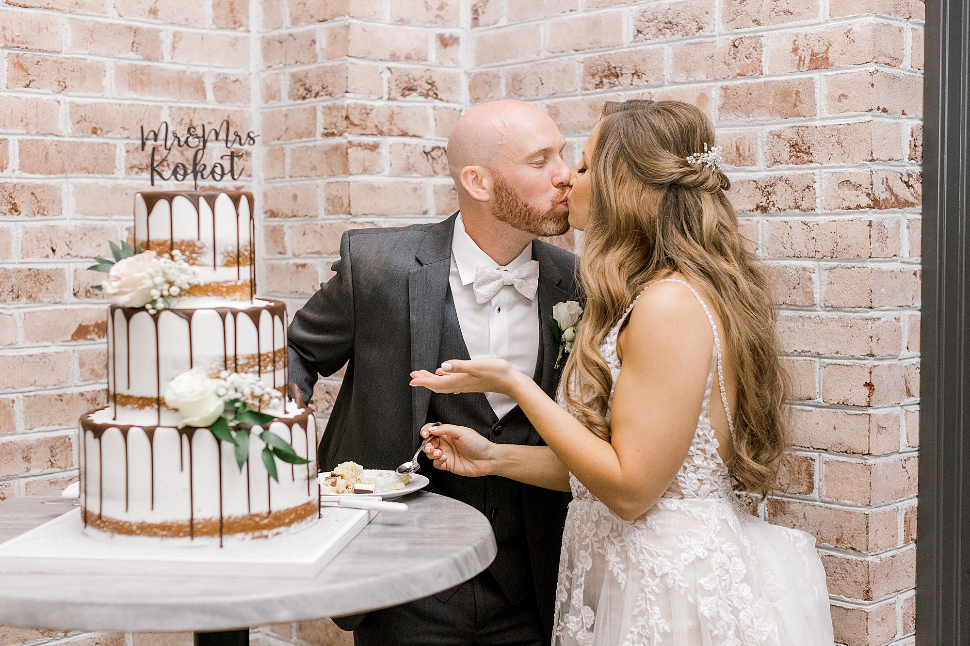 newlyweds kiss by make wedding cake with chocolate drizzle