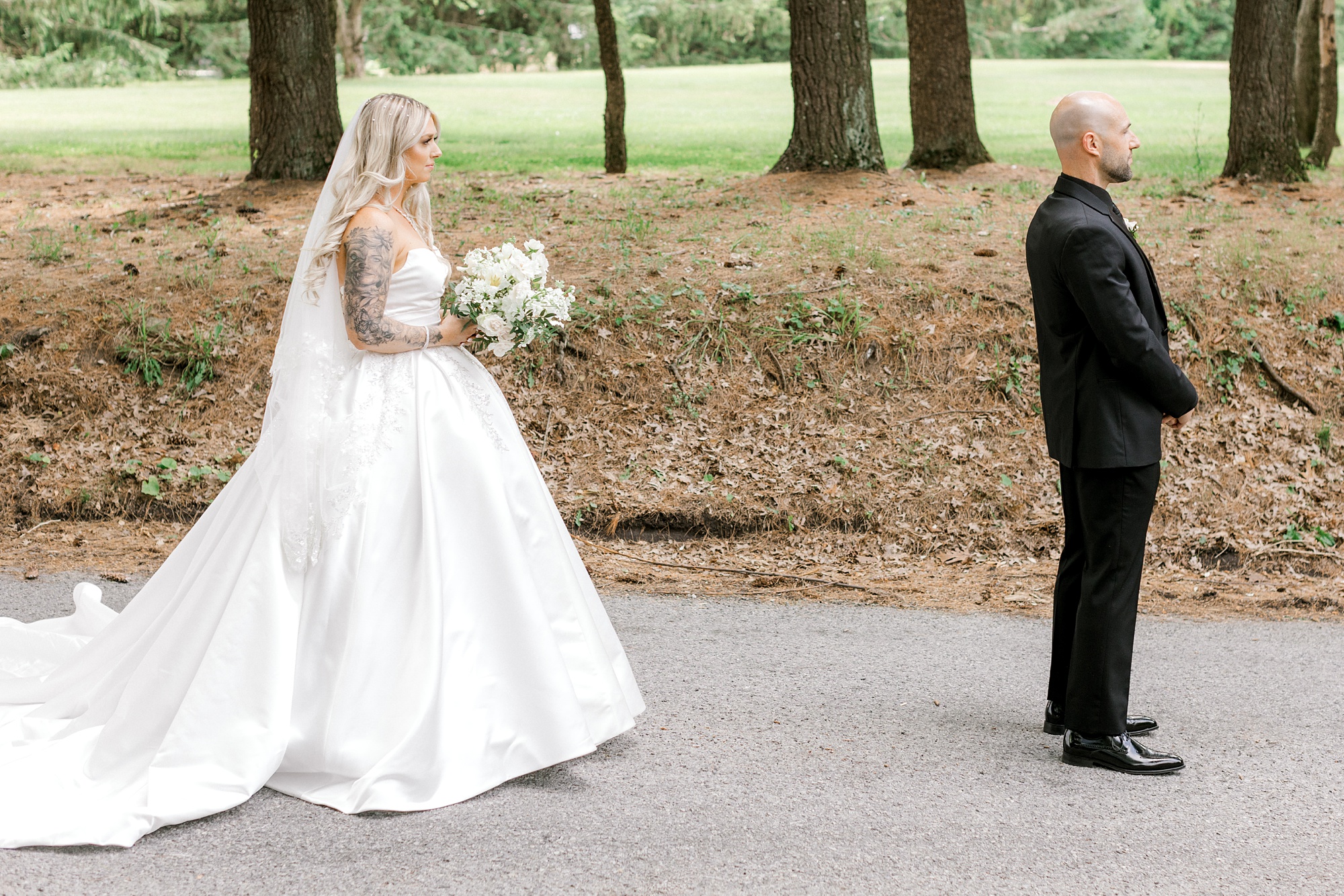 bride walks to meet groom for first look on driveway at the Refinery at Perona Farms