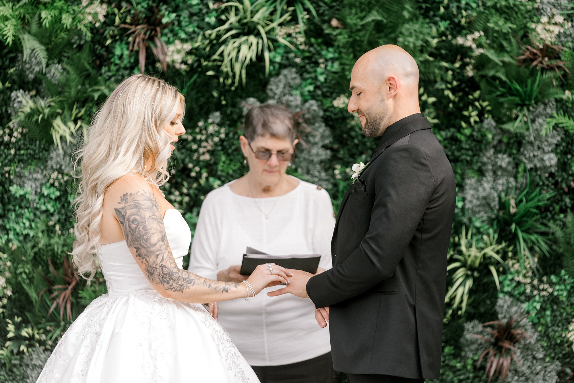 bride and groom smile exchanging rings during NJ wedding ceremony