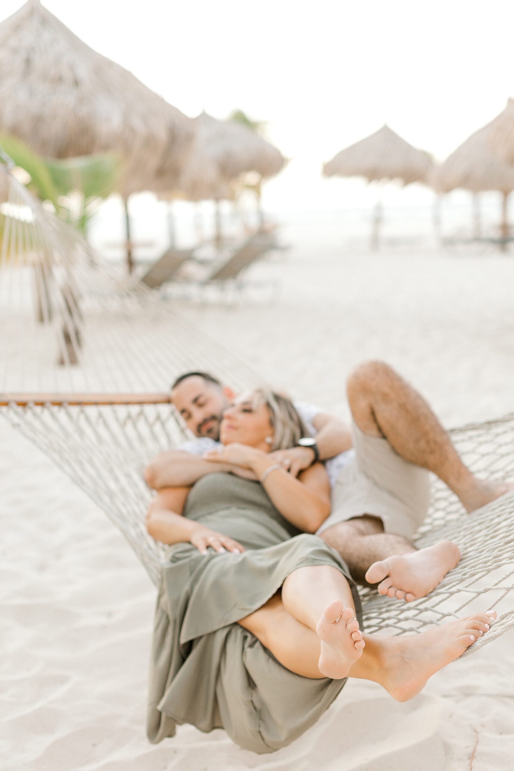 couple lays together in hammock snuggling during Aruba honeymoon photos