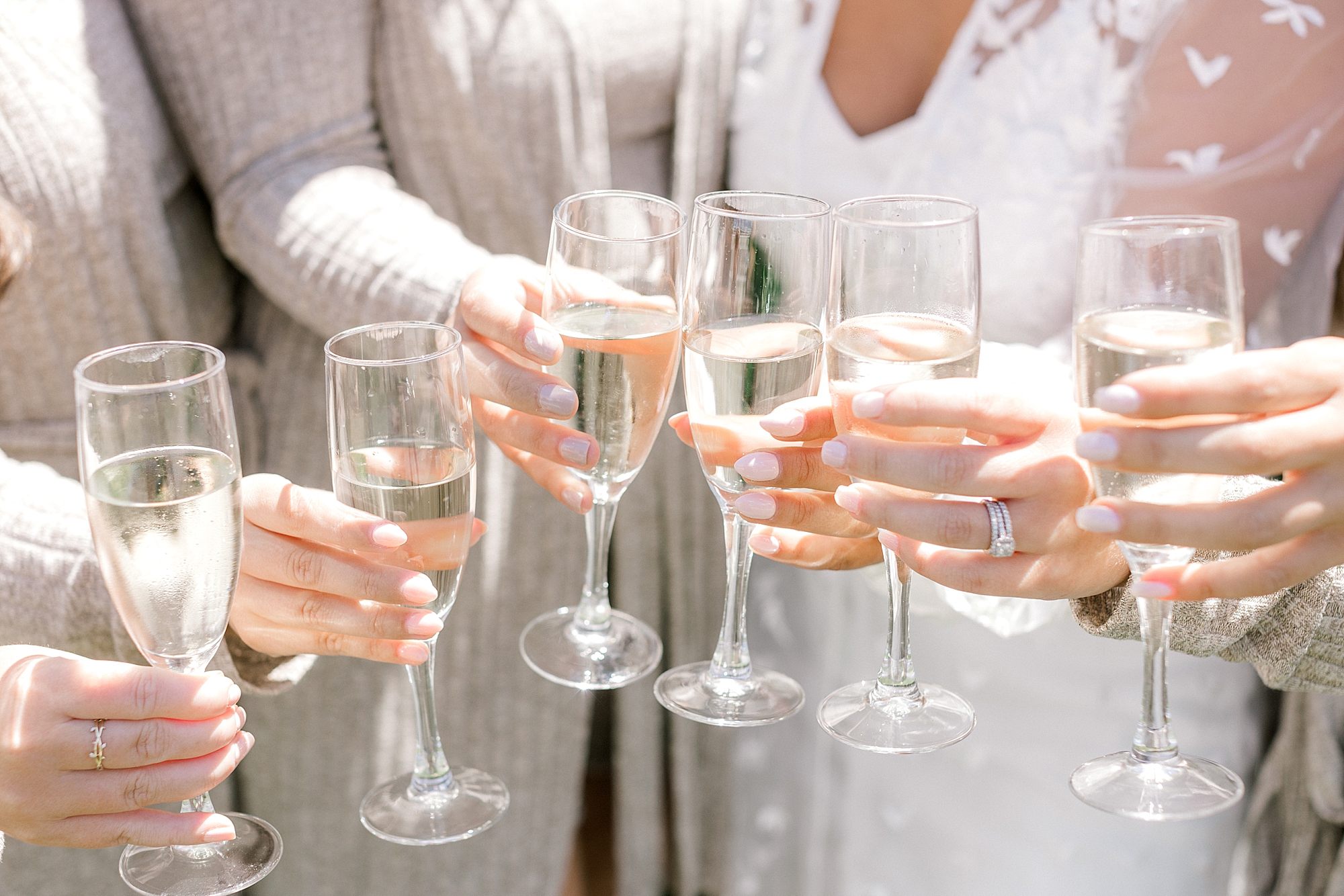 bride and bridesmaids toast champagne glasses