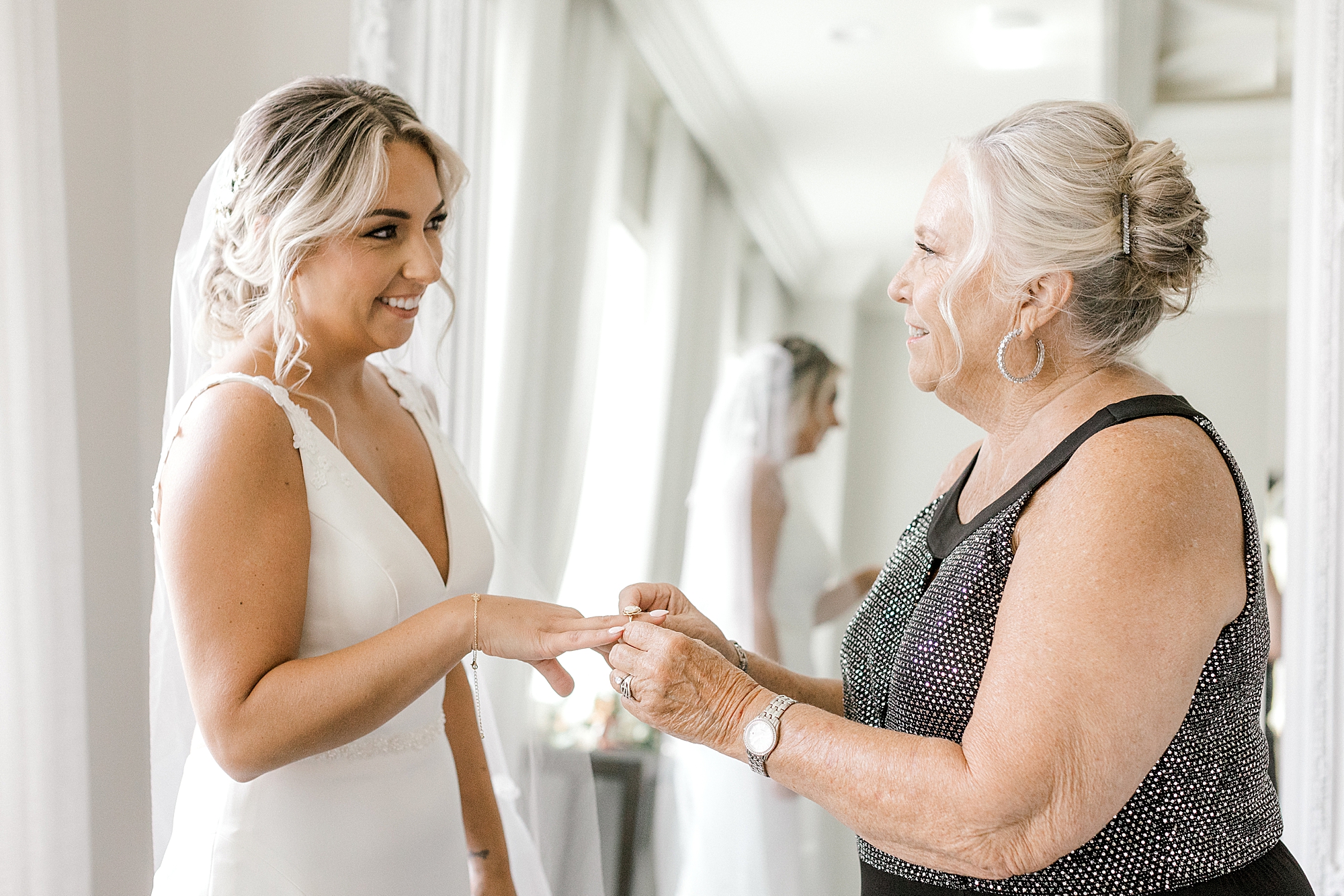 woman helps bride put on jewelry at the Mansion at Mountain Lakes