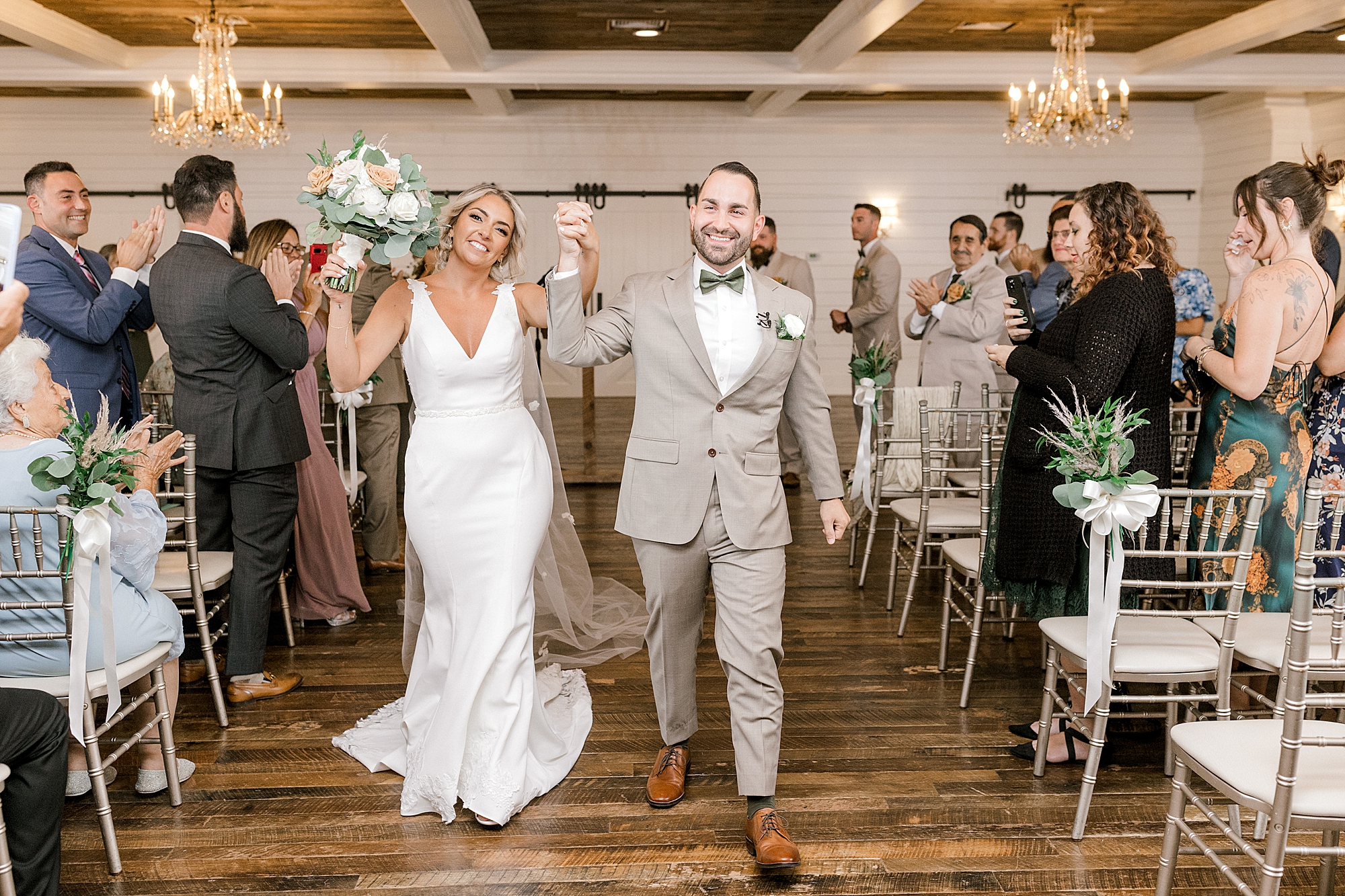 newlyweds walk up aisle cheering after wedding ceremony in New Jersey