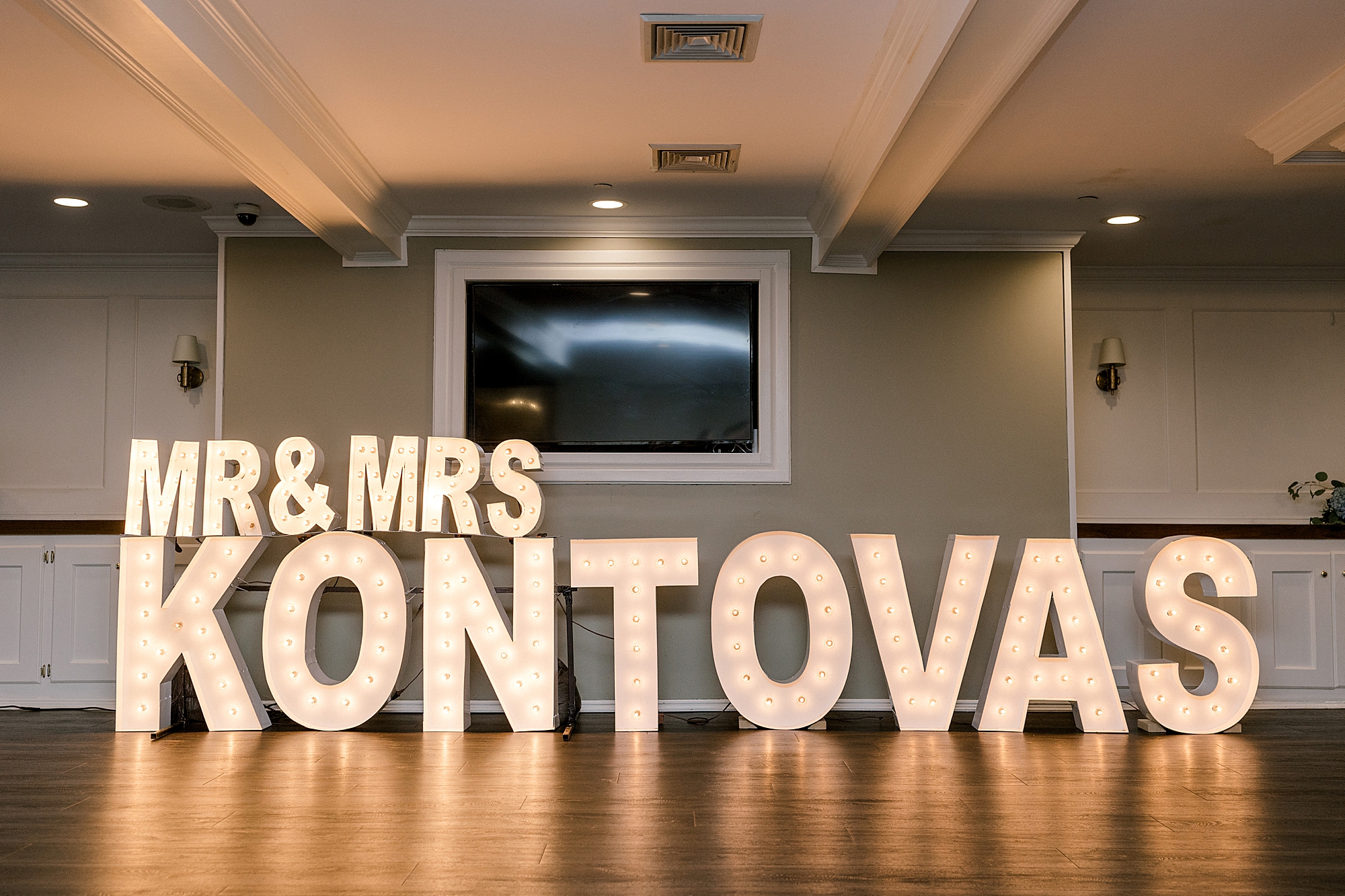 large marquee letters lit in couple's new last name on dance floor
