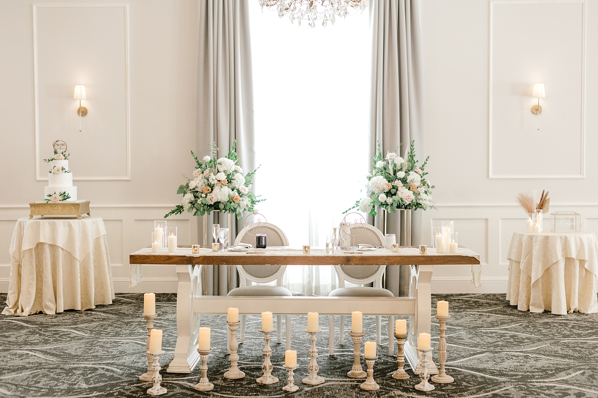 sweetheart table with flowers and candles underneath at wedding reception at the Mansion at Mountain Lakes