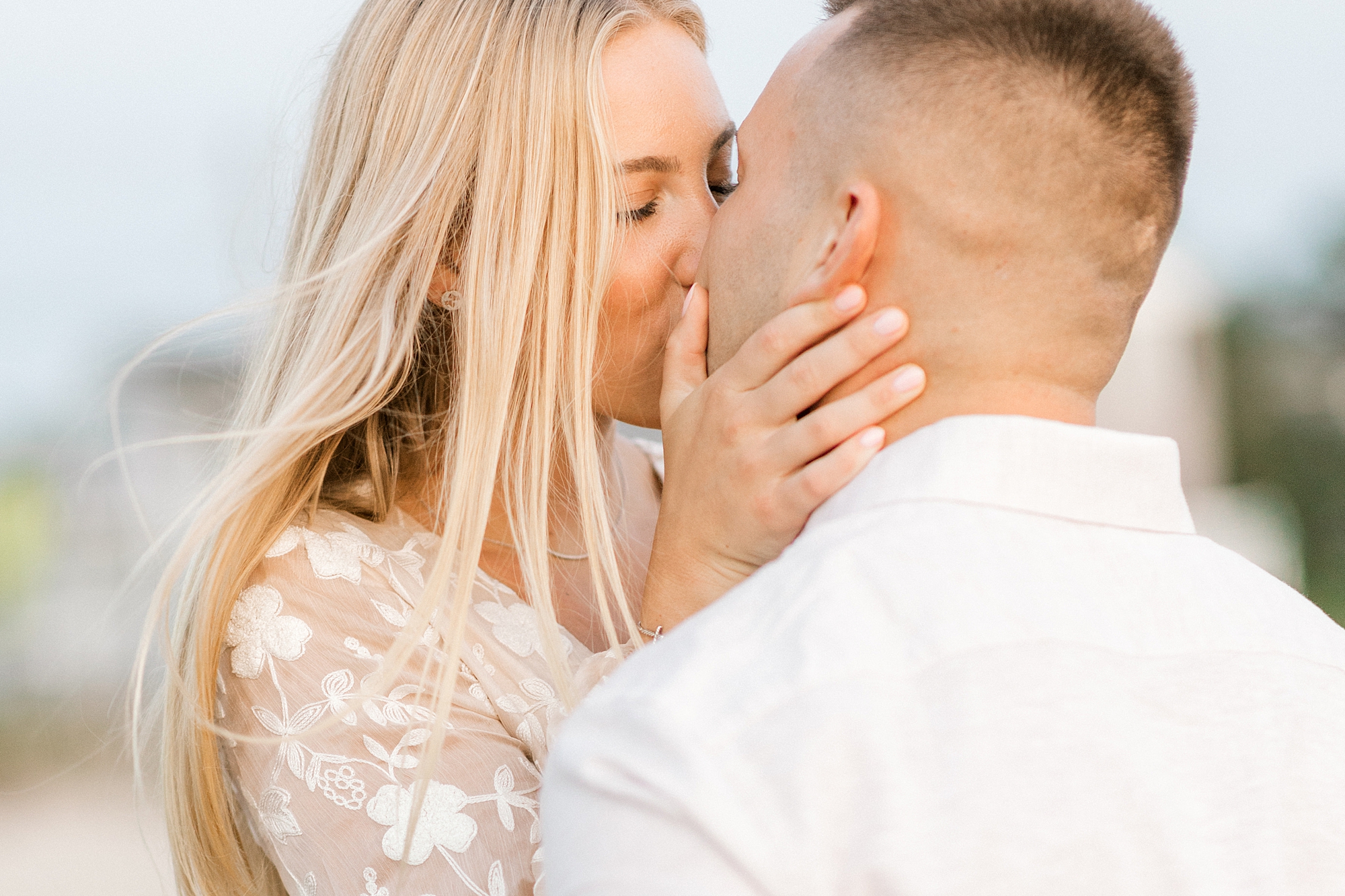 couple kisses on beach during engagement session in Lavallette, NJ