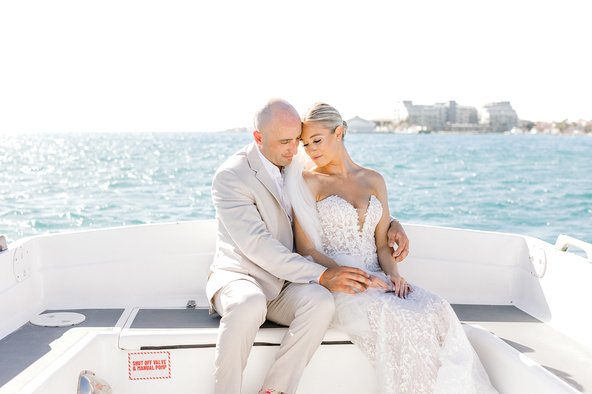 newlyweds sit on boat riding to Flamingo Island from the Renaissance Aruba