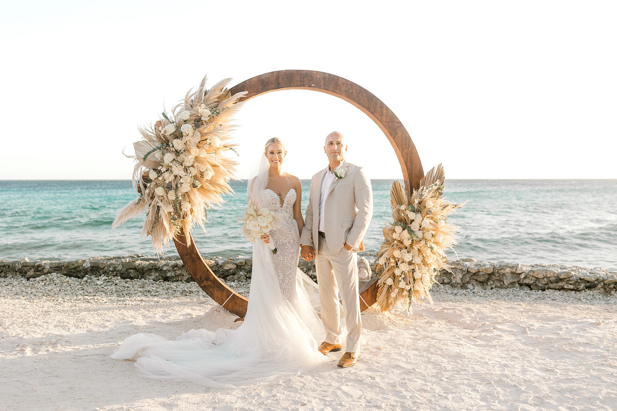 newlyweds stand near circular floral installation during ceremony on Flamingo Island
