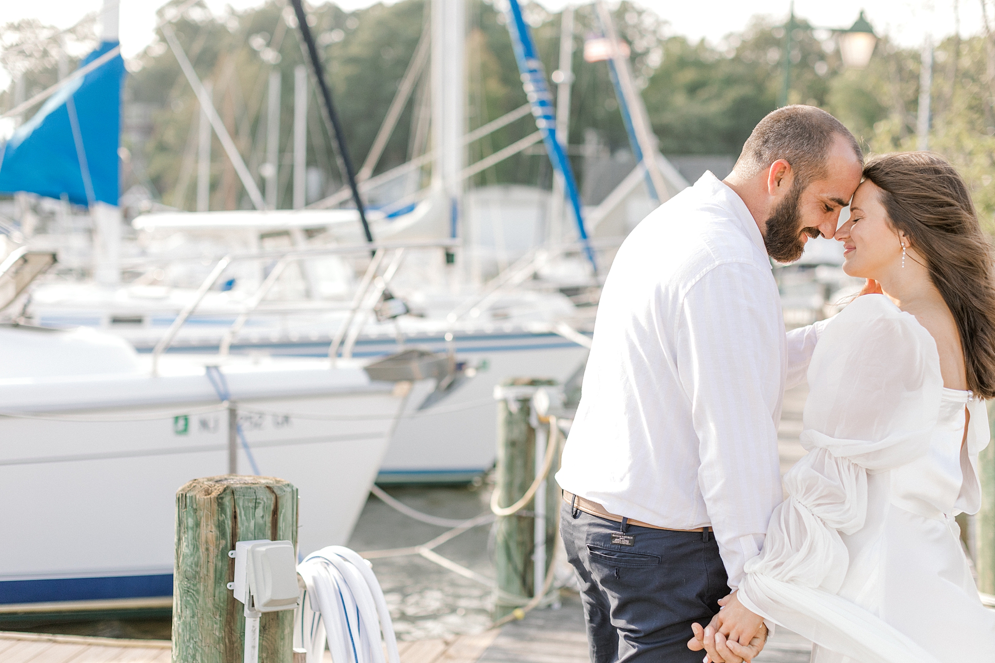 couple leans heads together in Toms River marina