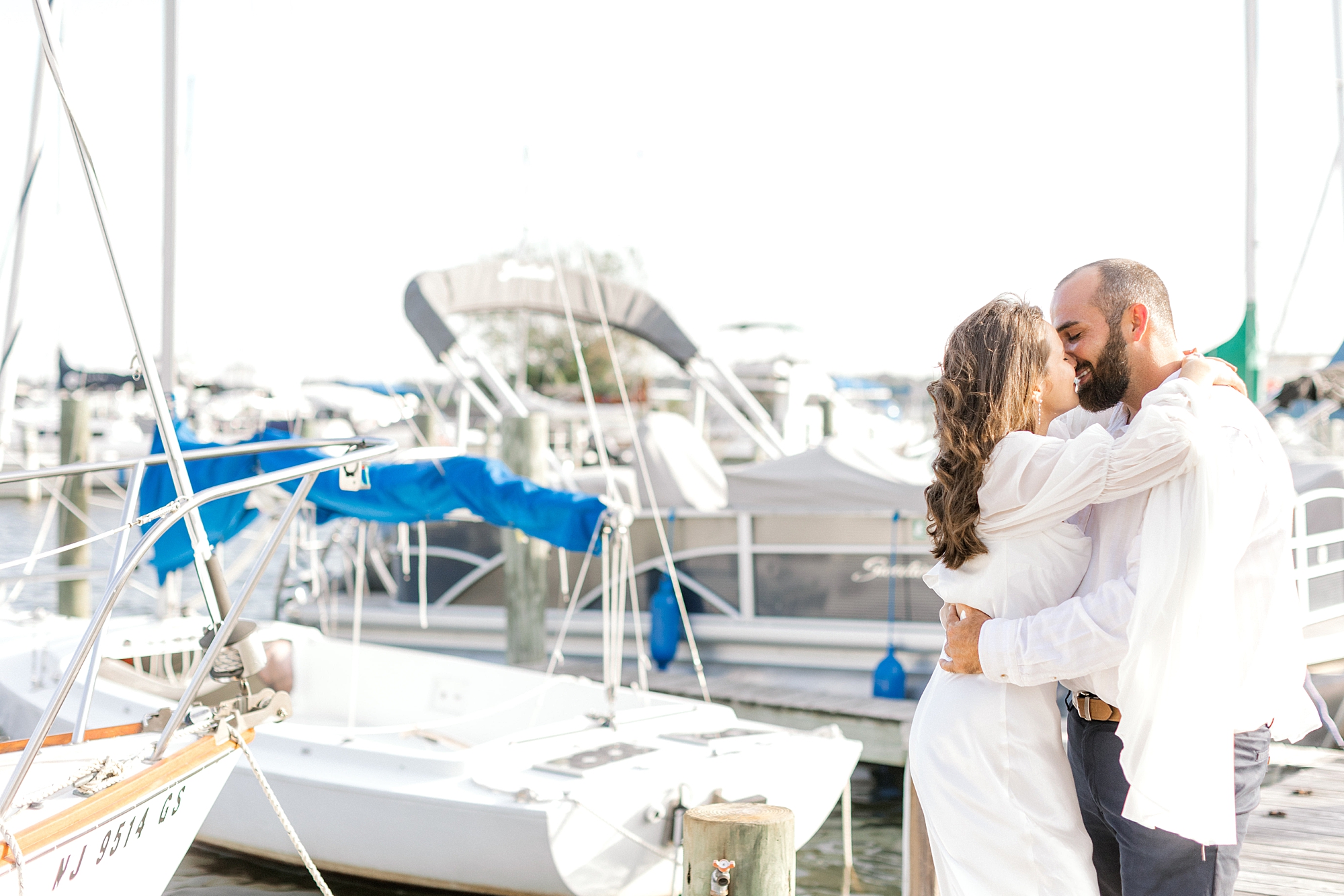 engaged couple kisses near boats in Toms River NJ
