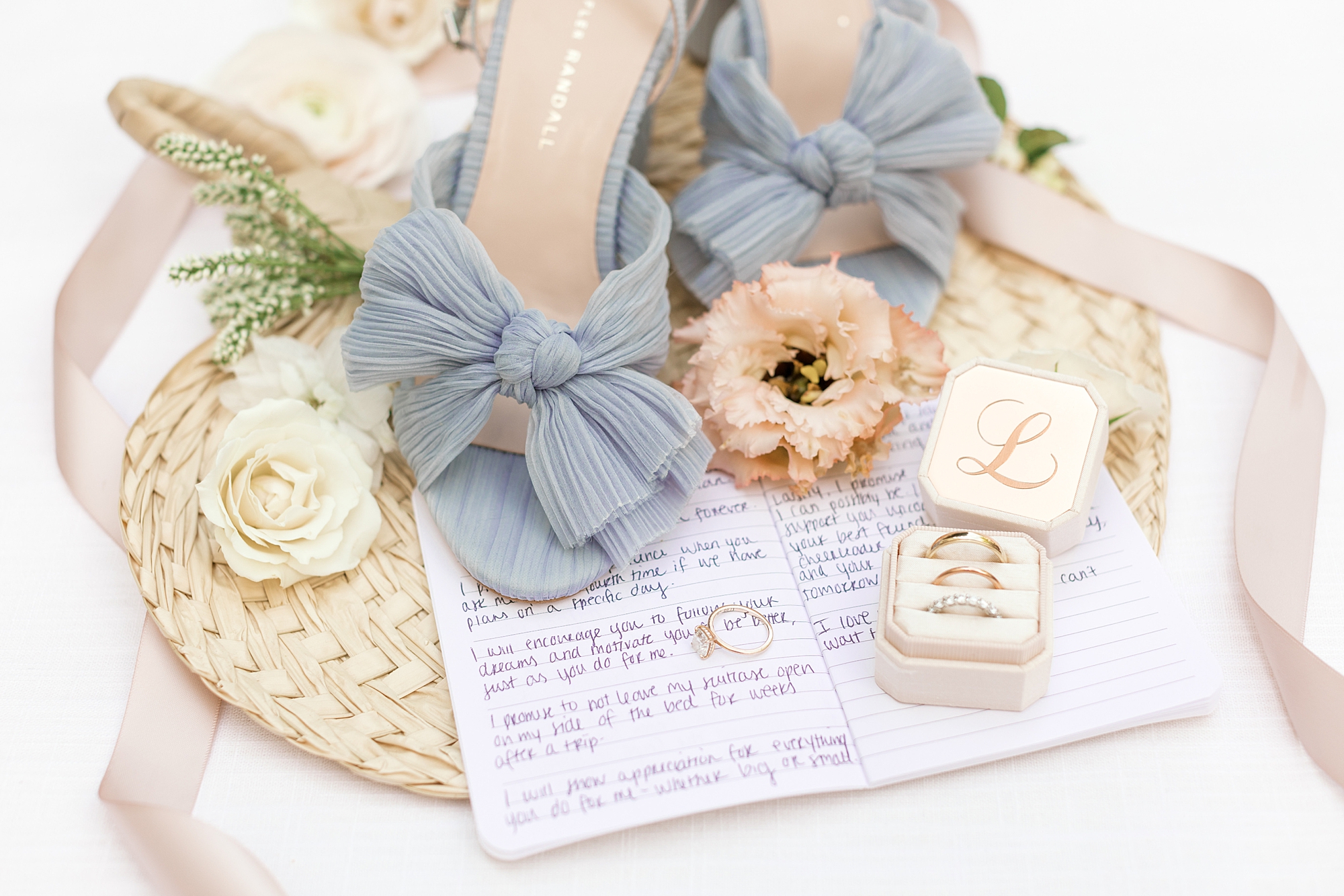 bride's blue shoes rest on vow booklet with peach and gold details in New Jersey