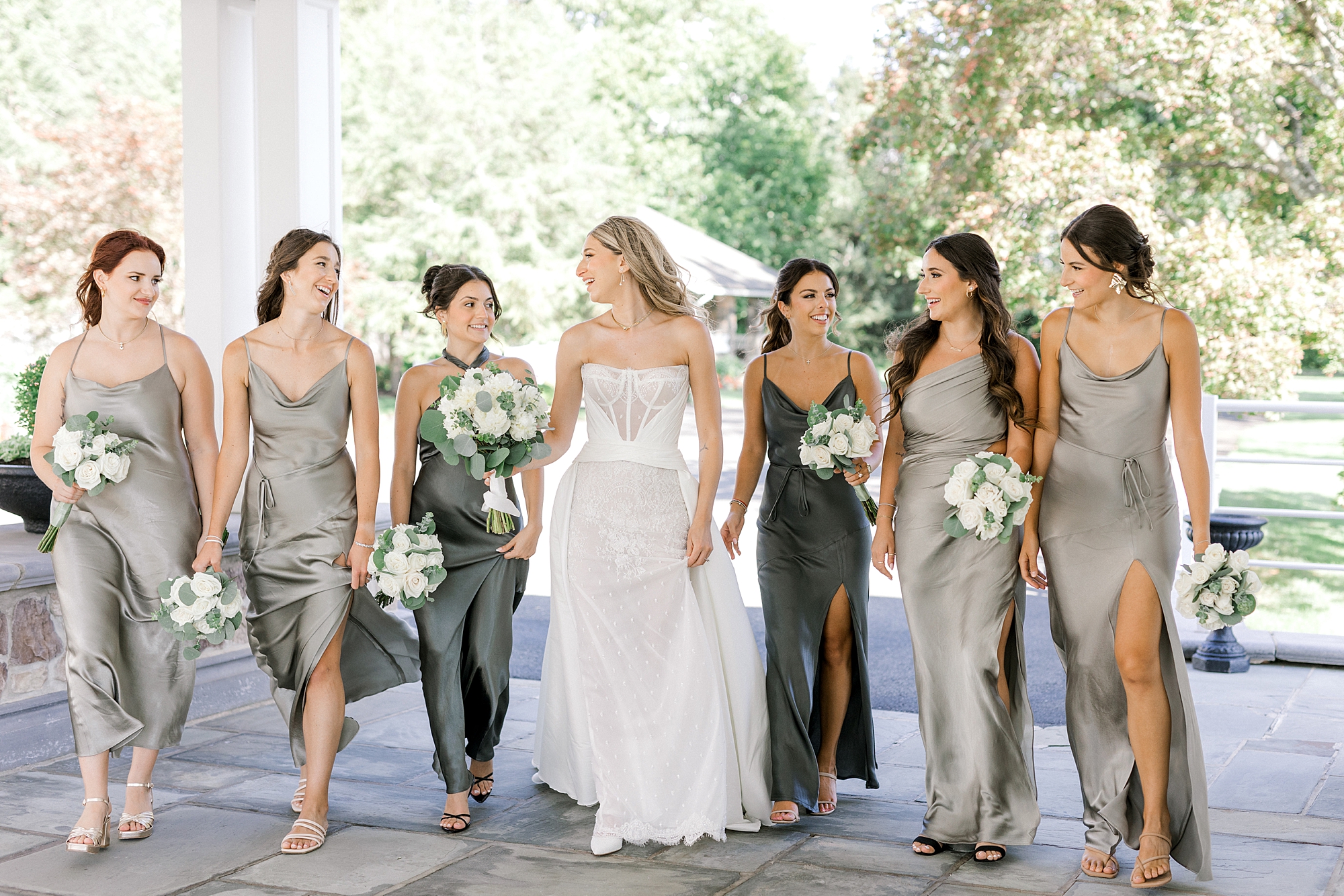 bride and bridesmaids walk outside Ryland Inn in green gowns