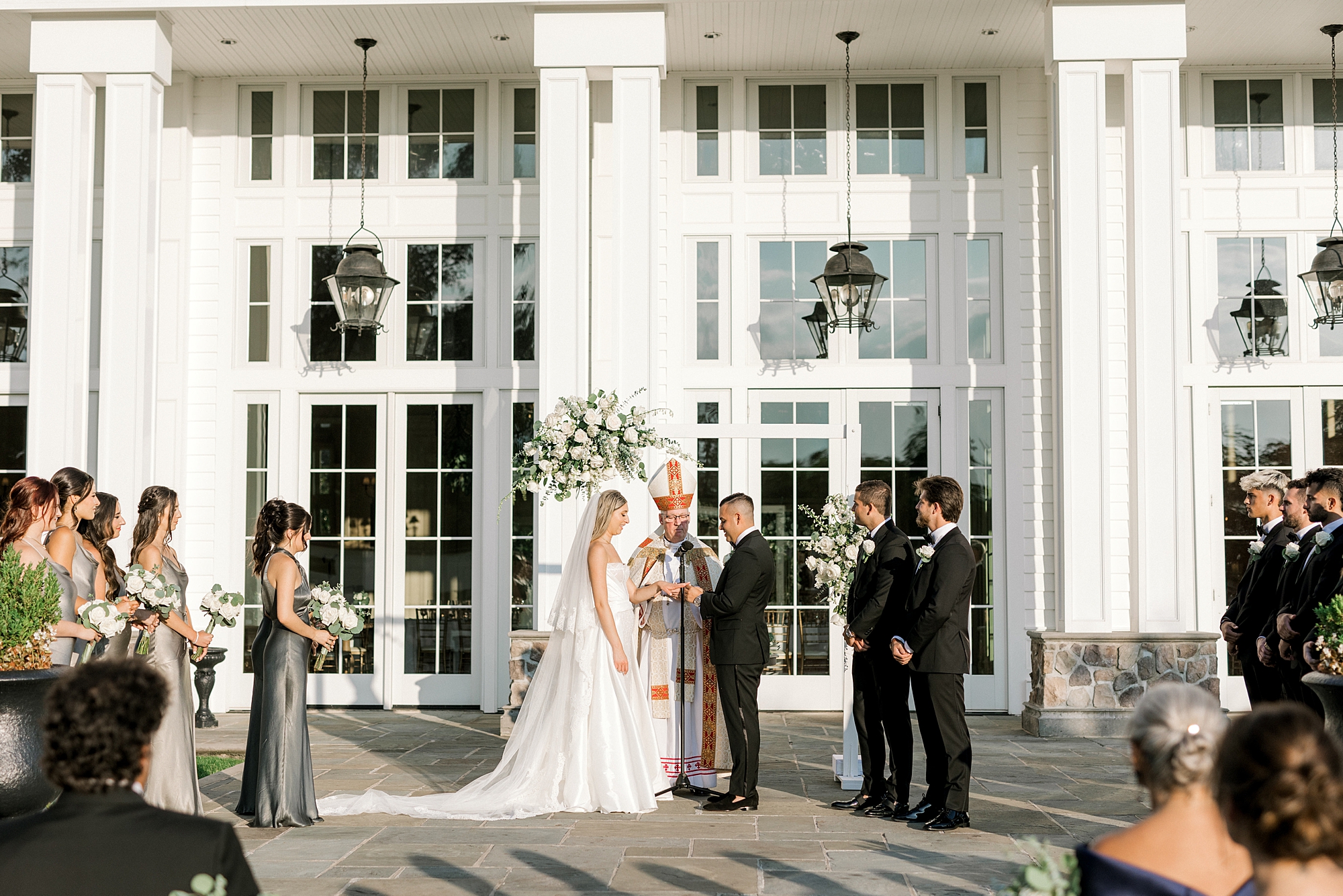bride and groom exchange vows during ceremony on patio at Ryland Inn