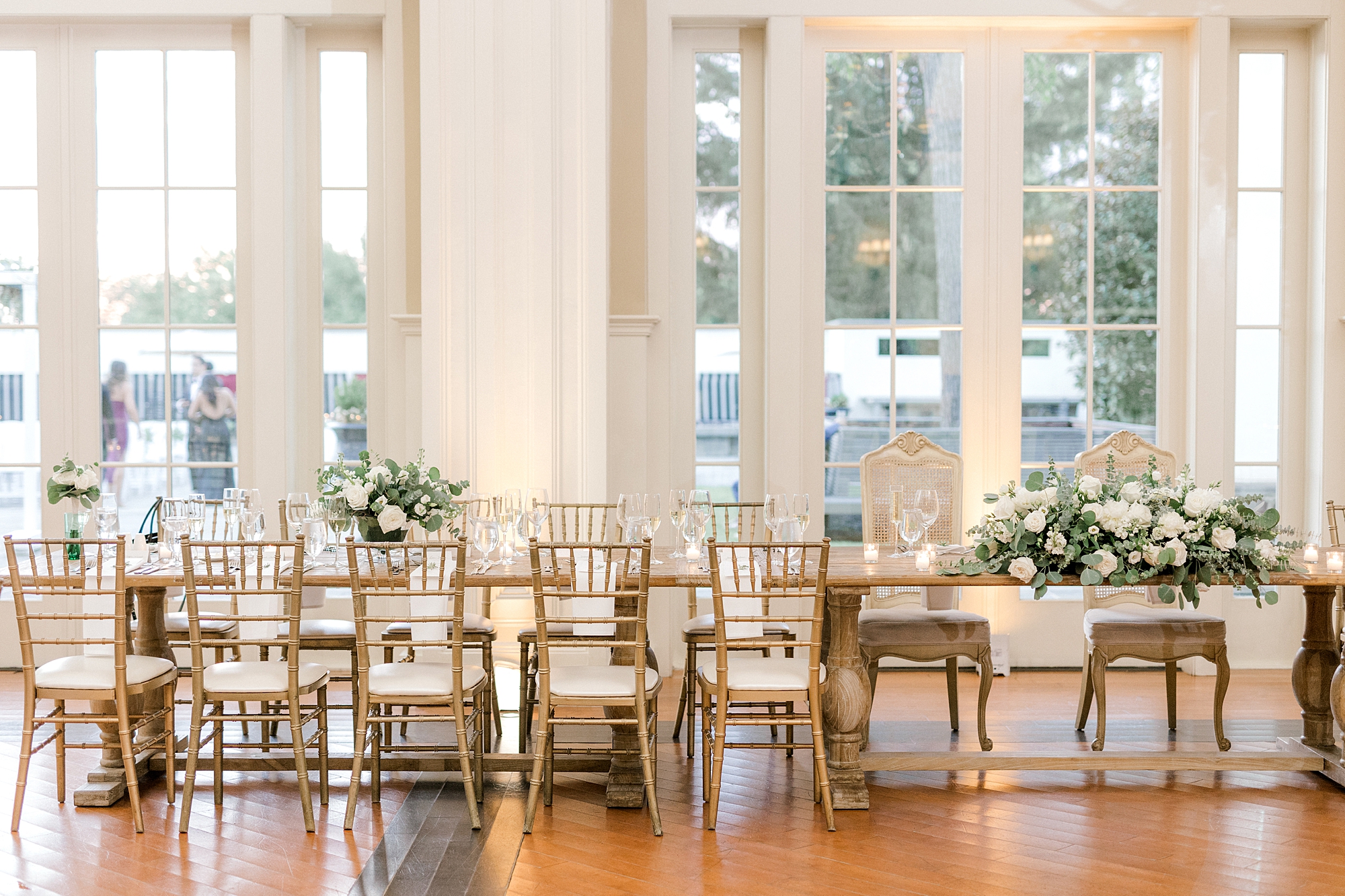 wedding reception at Ryland Inn with long wood tables and white and green florals
