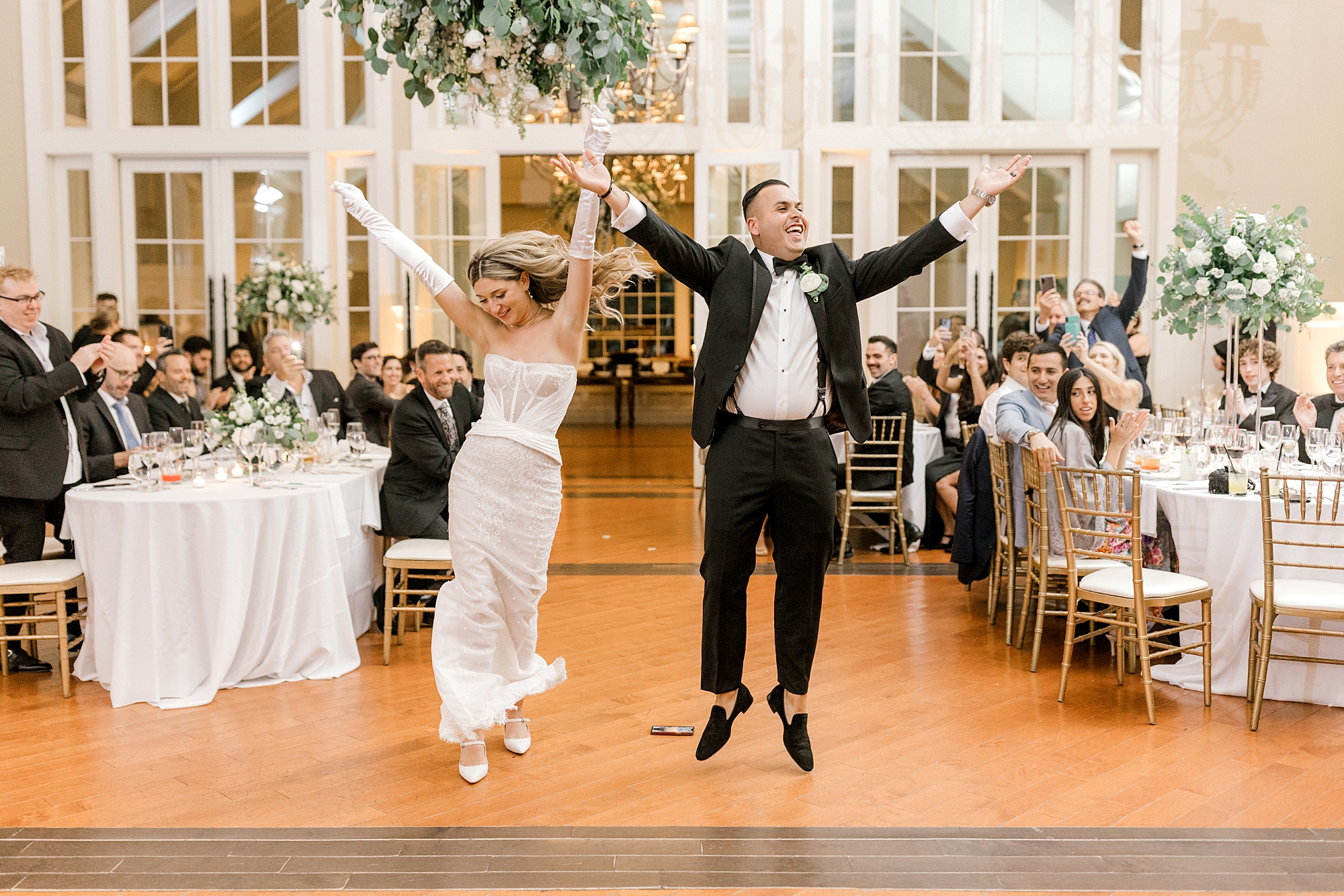 bride and groom cheer dancing into wedding reception