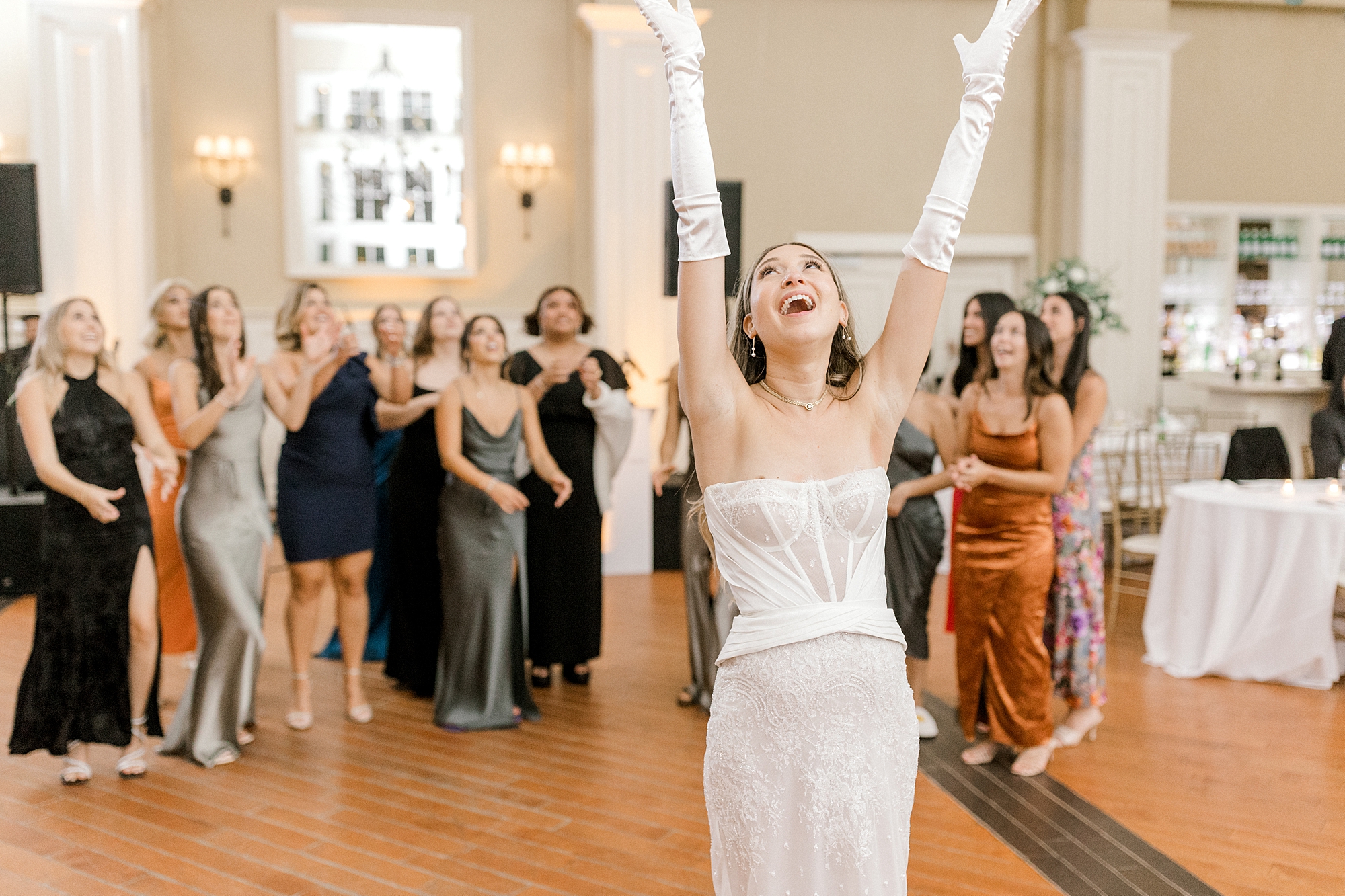 bride tosses bouquet in air during NJ wedding reception at Ryland Inn
