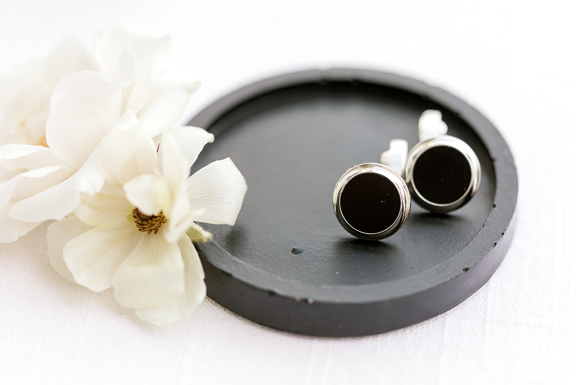 groom's custom black and silver cufflinks and white flower