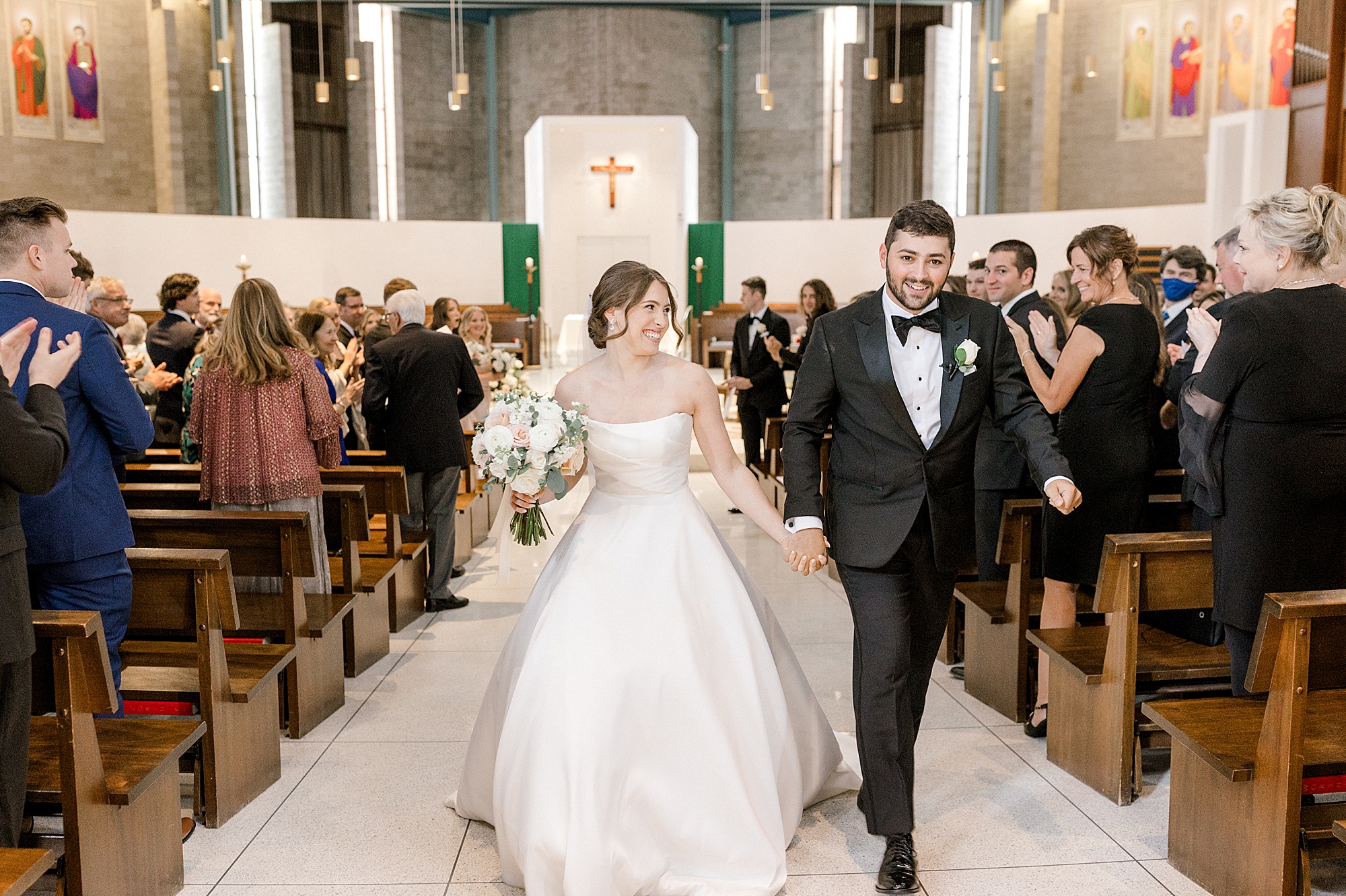 bride and groom hold hands leaving church after traditional church wedding in New Jersey