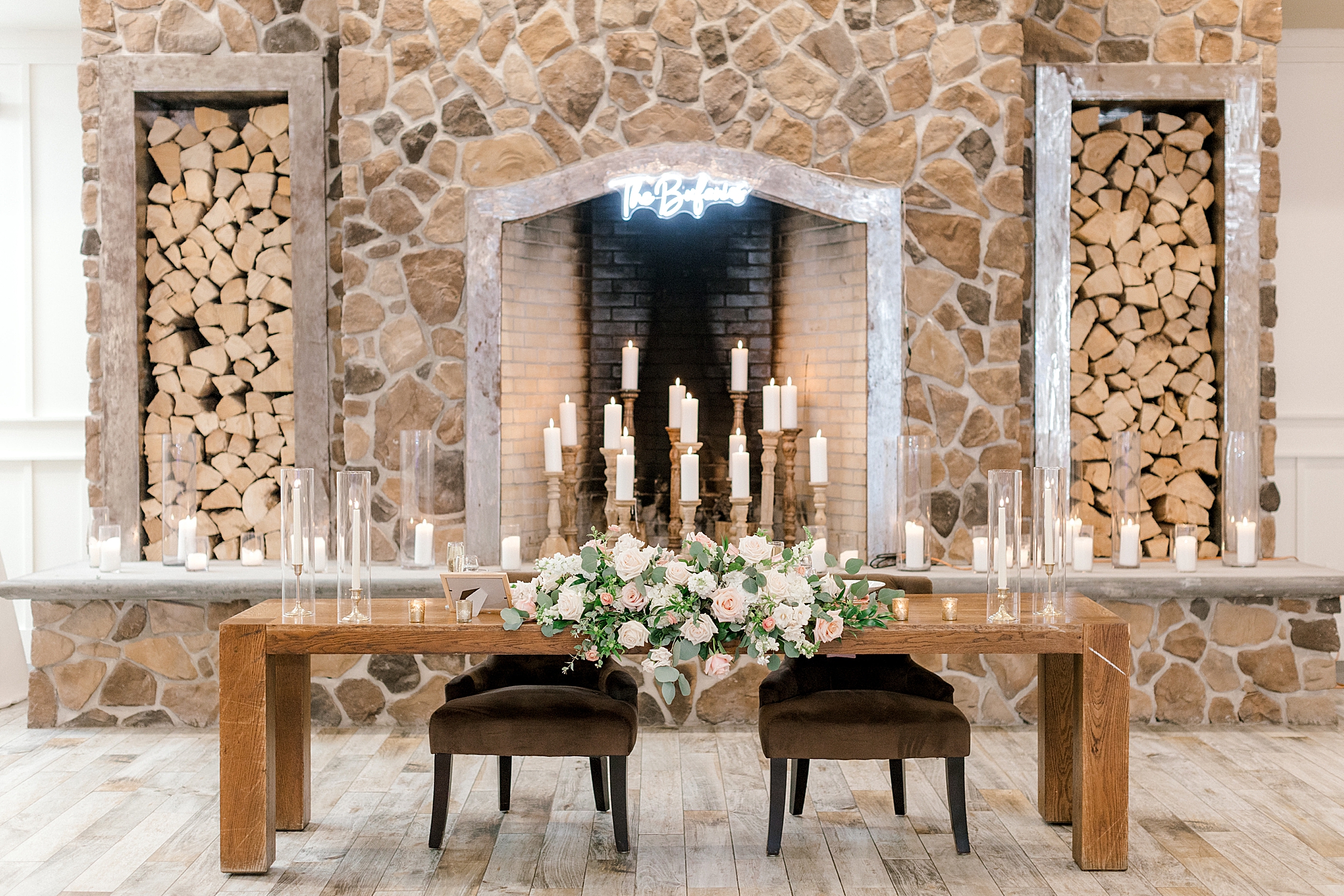 wedding sweetheart table in front of stone fireplace at the Farmhouse