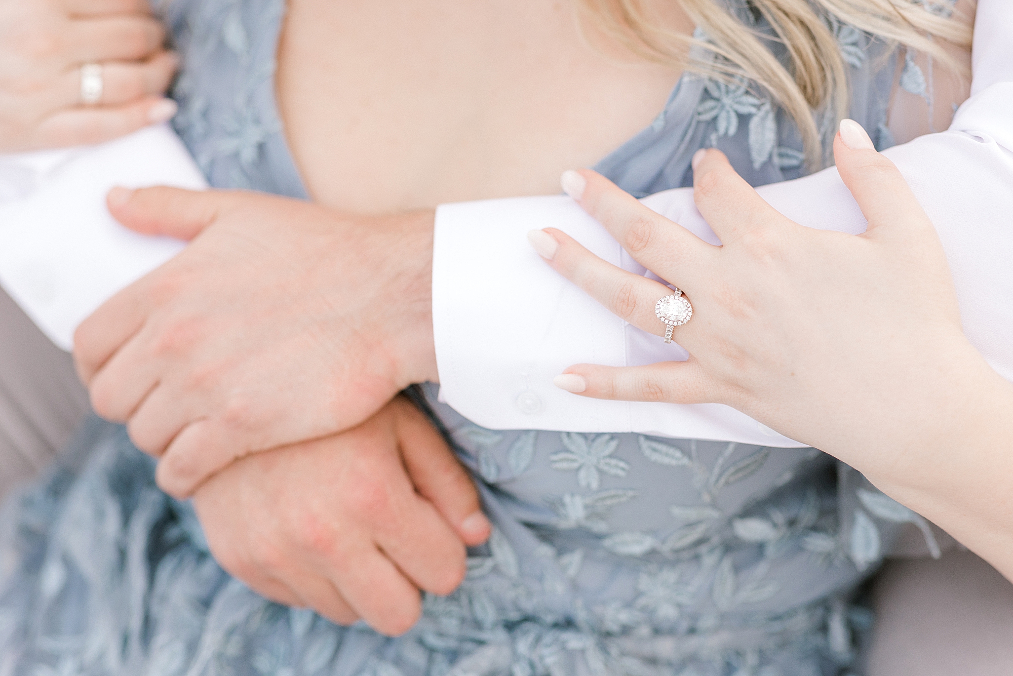 woman holds man's arm showing off diamond ring