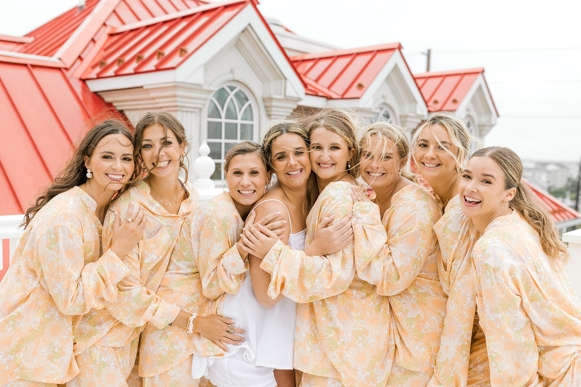 bride hugs bridesmaids in custom floral robes