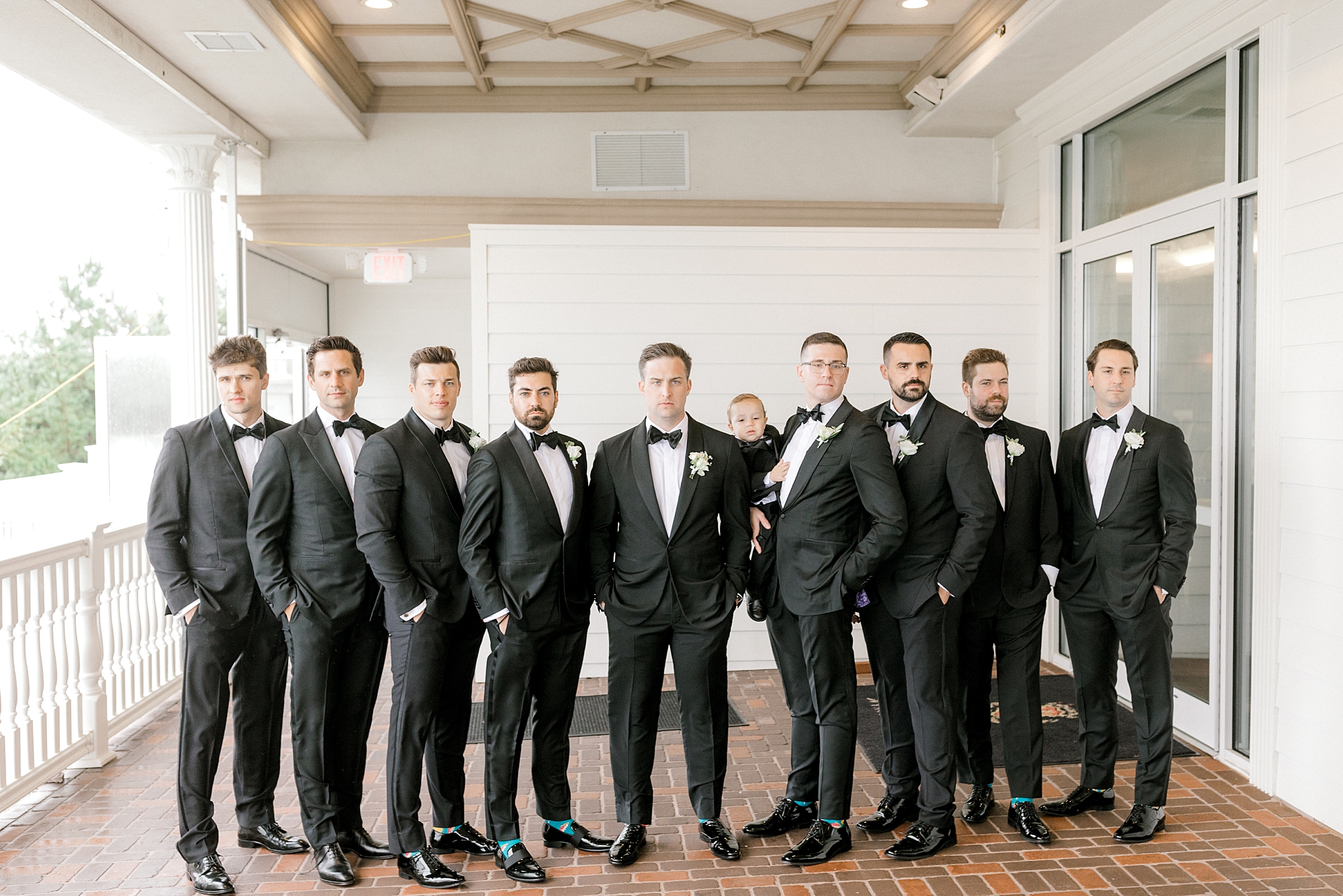 groom stands with groomsmen at Mallard Island Yacht Club