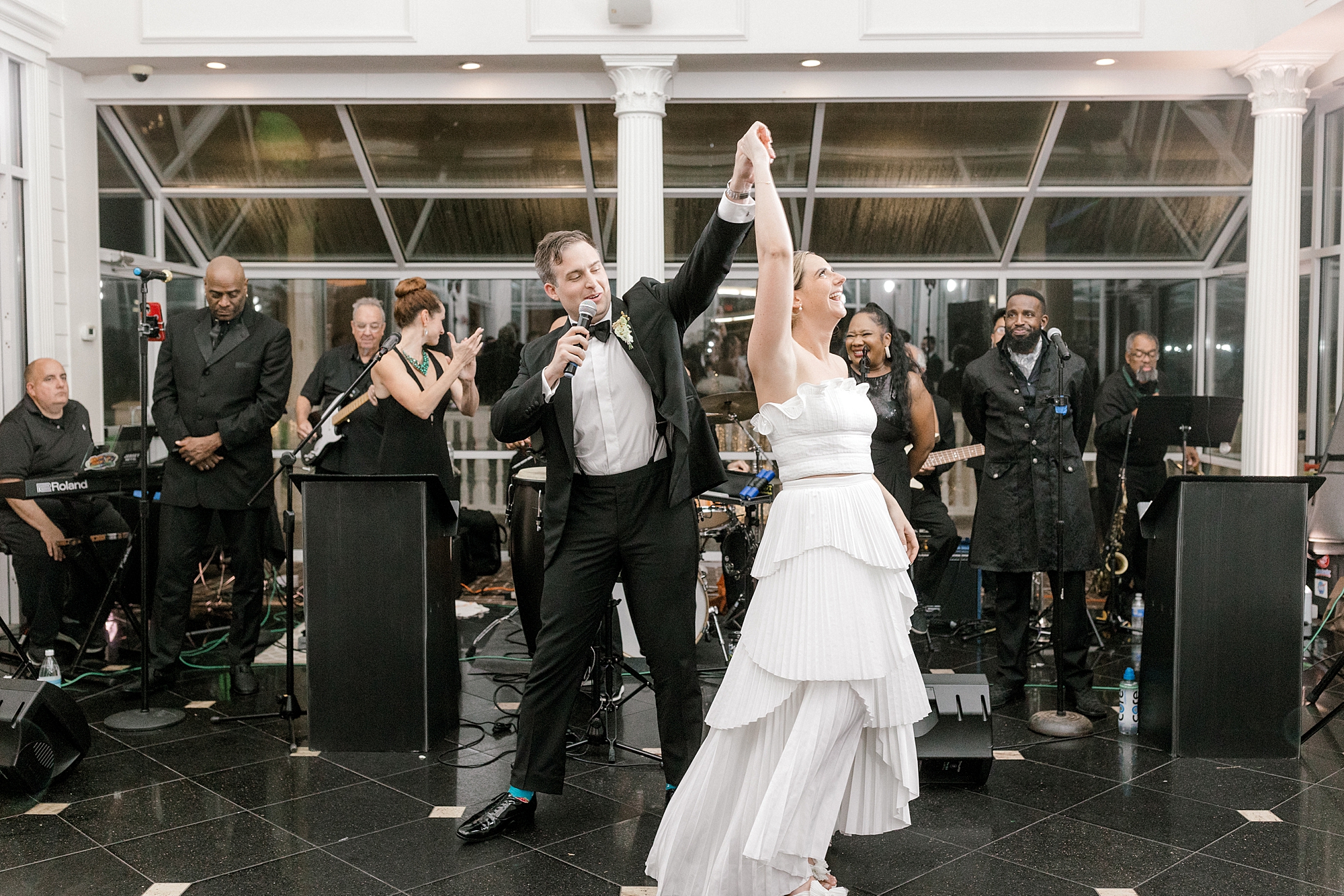 groom twirls bride under his arm during speech at Long Beach Island wedding reception
