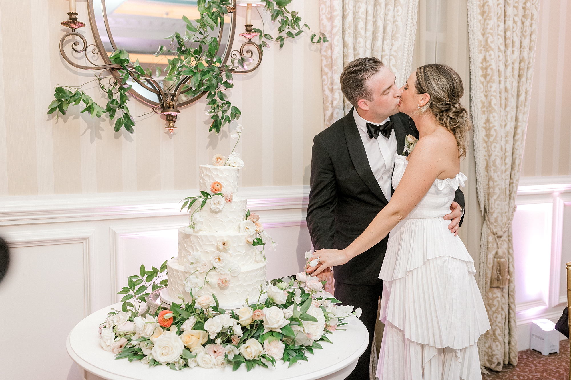 bride and groom kiss during cake cutting at Long Beach Island wedding reception