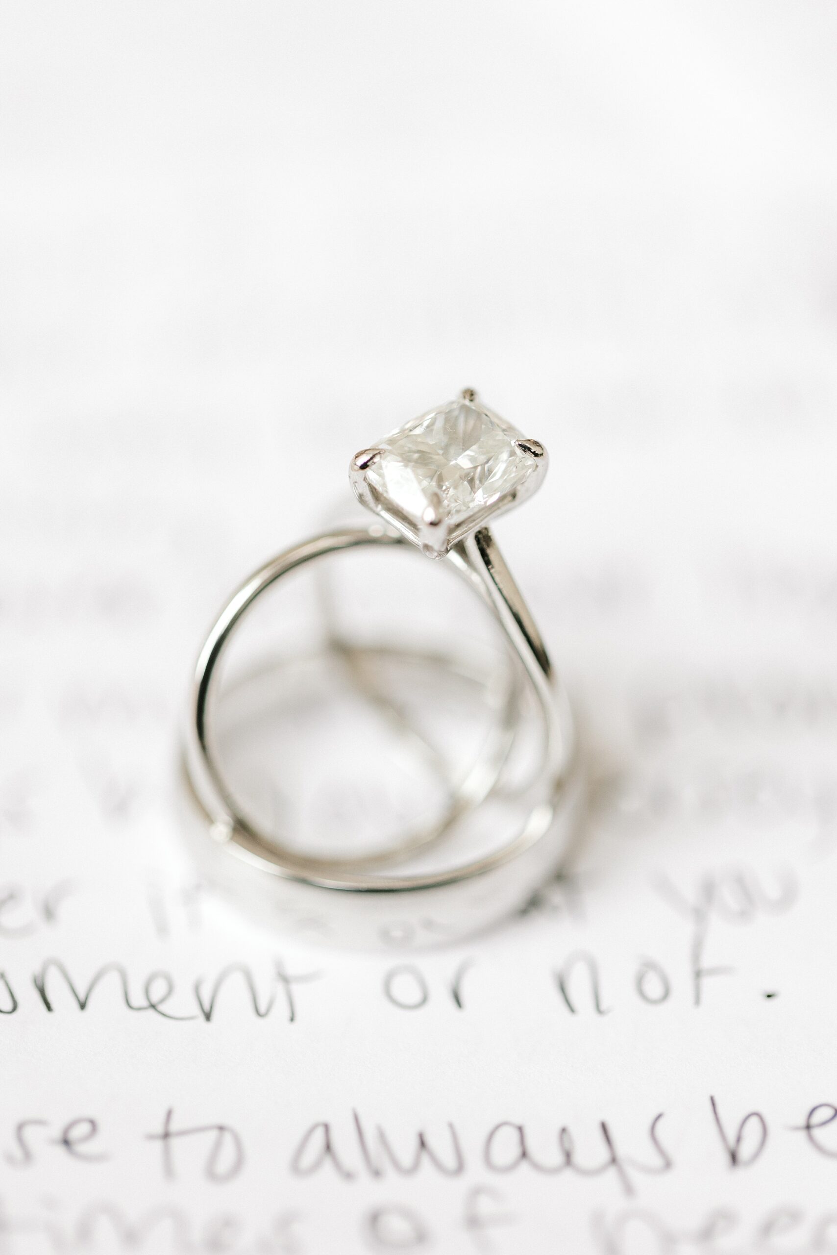 diamond ring stacked on handwritten vows at Mallard Island Yacht Club