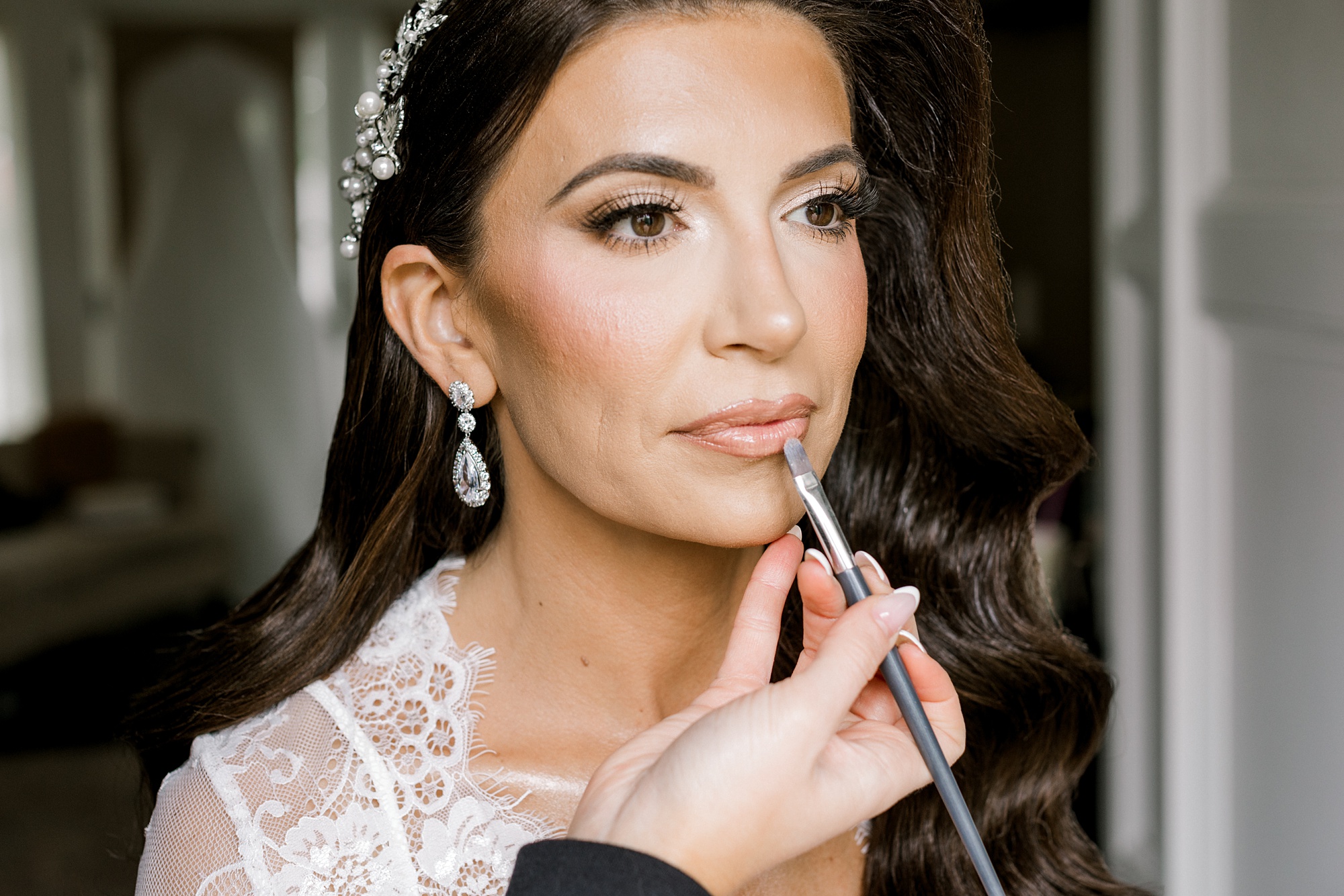 makeup artist applies lip gloss for bride on wedding day in New Jersey