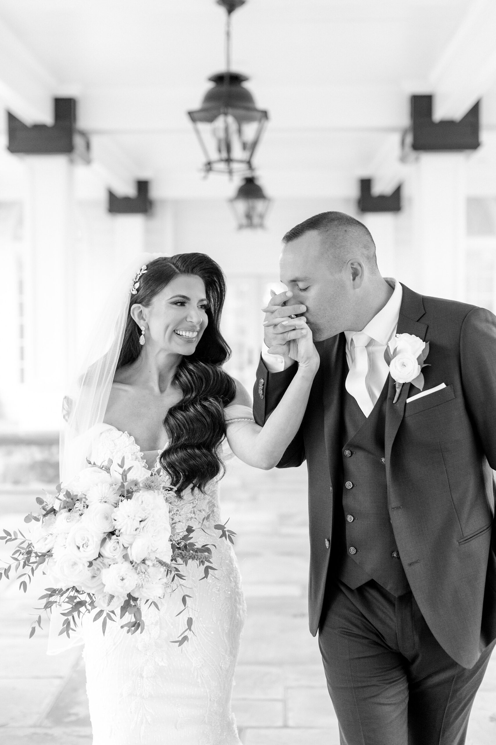 groom kisses bride's hand during NJ wedding photos at Ryland Inn