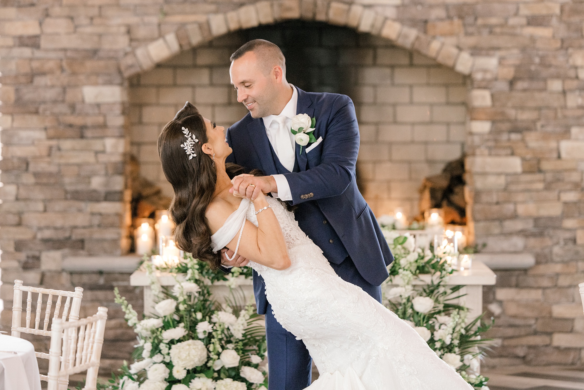 groom dips bride inside Ryland Inn by brick fireplace