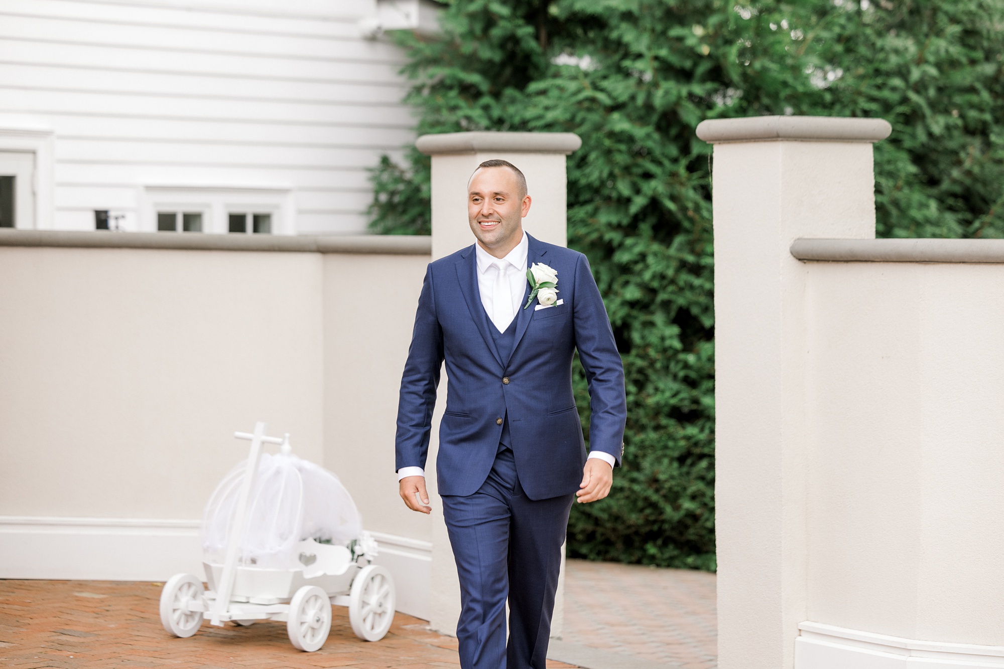 groom walks down aisle for wedding ceremony at Ryland Inn on the patio