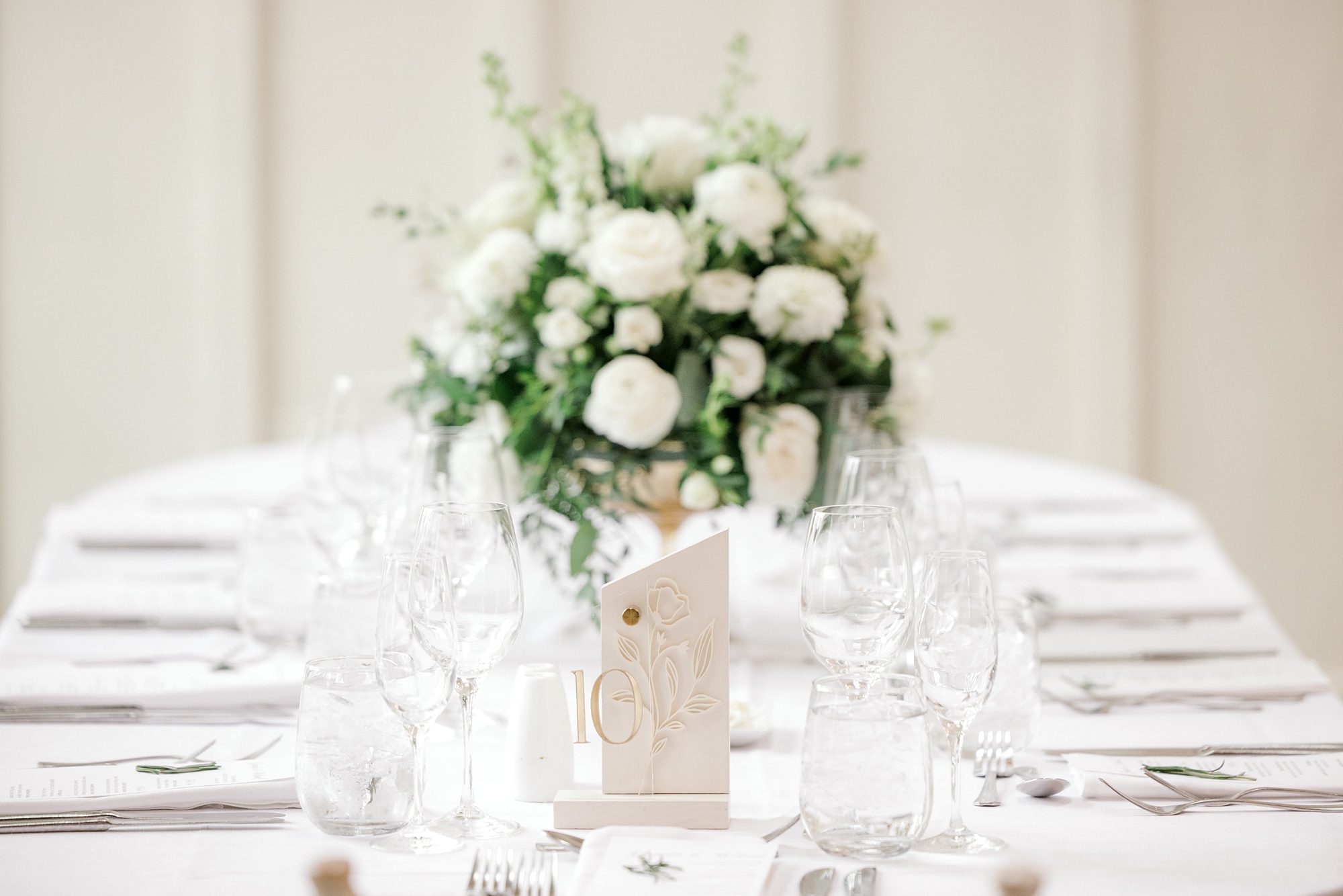 centerpieces with ivory flowers and white place settings for wedding reception at Ryland Inn