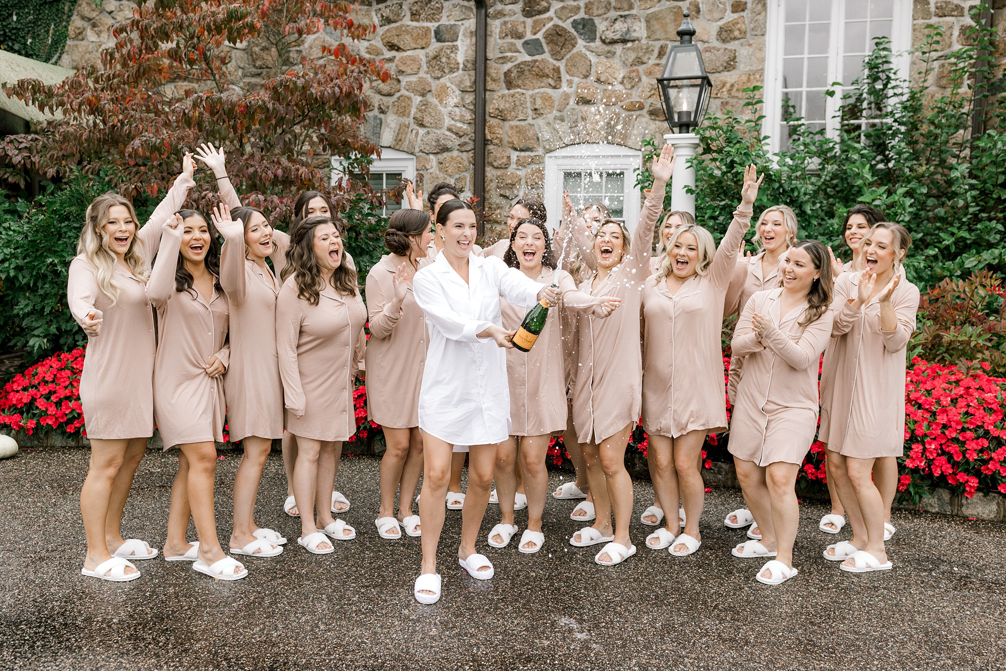 bridesmaids cheer when bride pops champagne during prep at Fiddler's Elbow Country Club