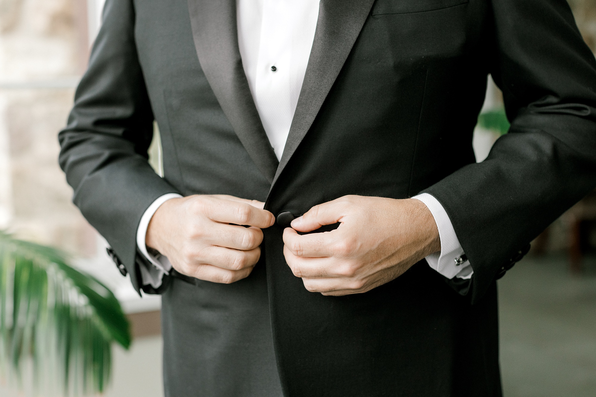groom buttons suit jacket during prep for NJ wedding day