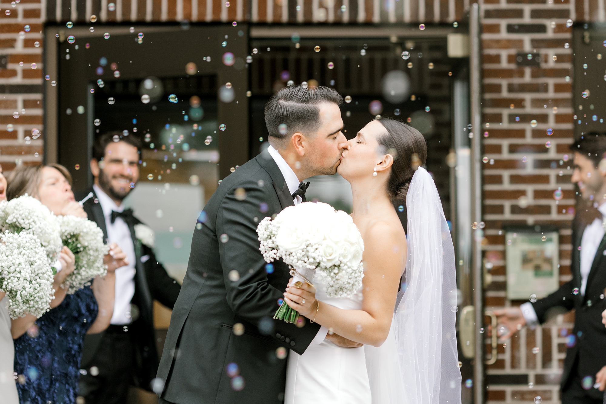 bride and groom kiss leaving New Jersey church ceremony in bubble exit