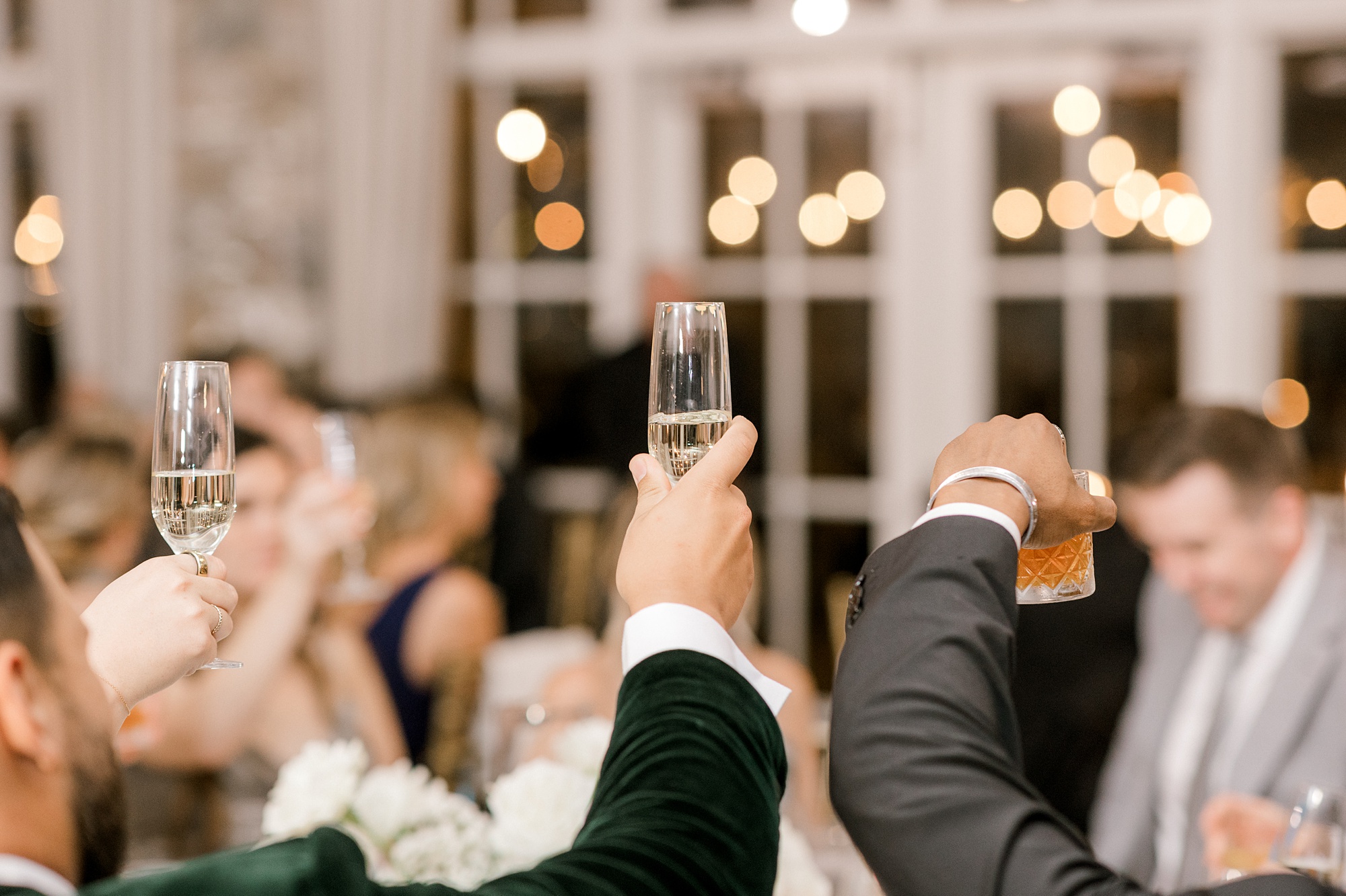 guests lift Champagne glasses during wedding reception at Fiddler's Elbow Country Club